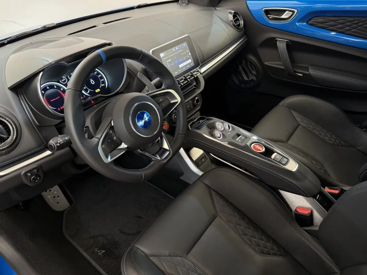Intérieur de l'Alpine A110 Legende 2019, vue côté conducteur, cuir noir et panneau de porte bleu vif.