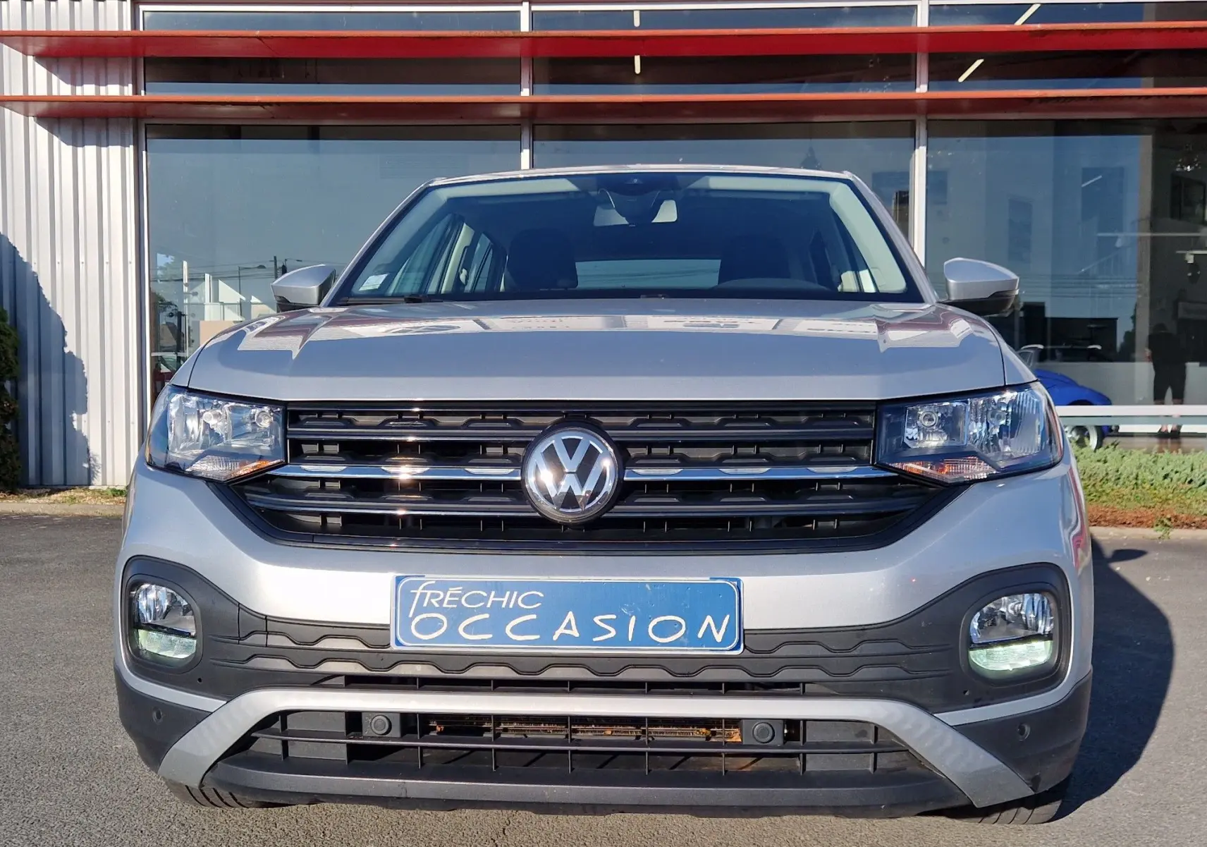 Vue frontale d'un Volkswagen T-Cross argent métal 2019 avec calandre noire et plaque d'occasion bleue.