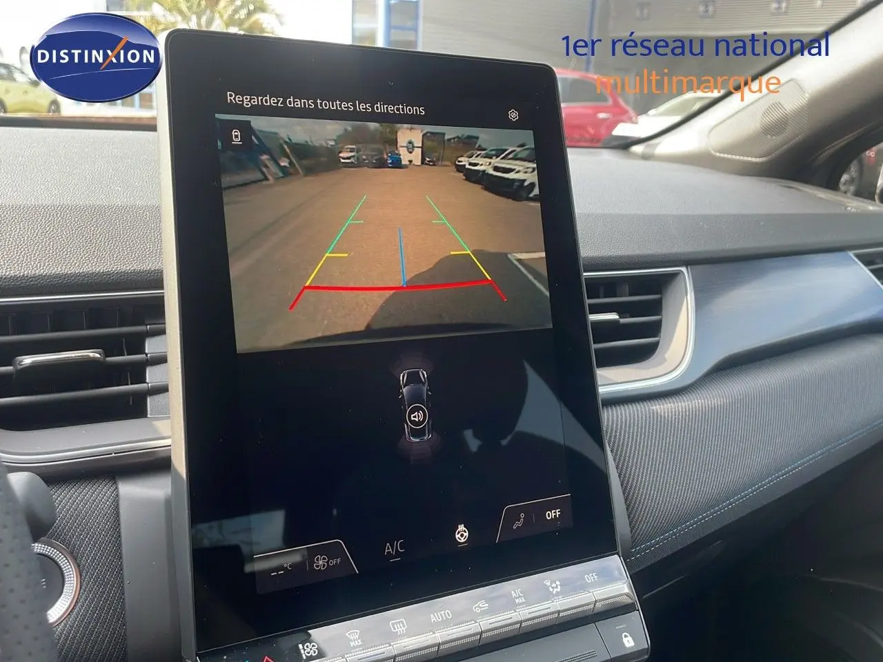 Écran central tactile montrant la caméra de recul du Renault Captur E-Tech gris cassiopée, intérieur moderne avec tableau de bord bleu.