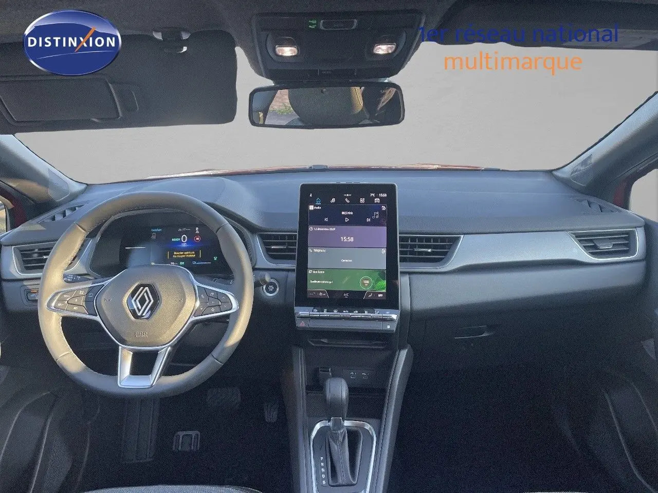 Vue intérieure du tableau de bord du Renault Captur E-Tech hybride 2025 avec écran tactile vertical et volant multifonction noir.