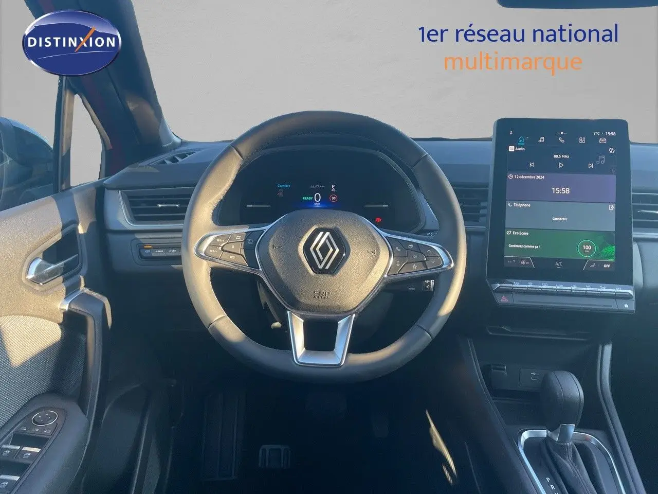Vue intérieure centrée sur le volant et l’écran tactile du Renault Captur E-Tech rouge passion avec toit noir.