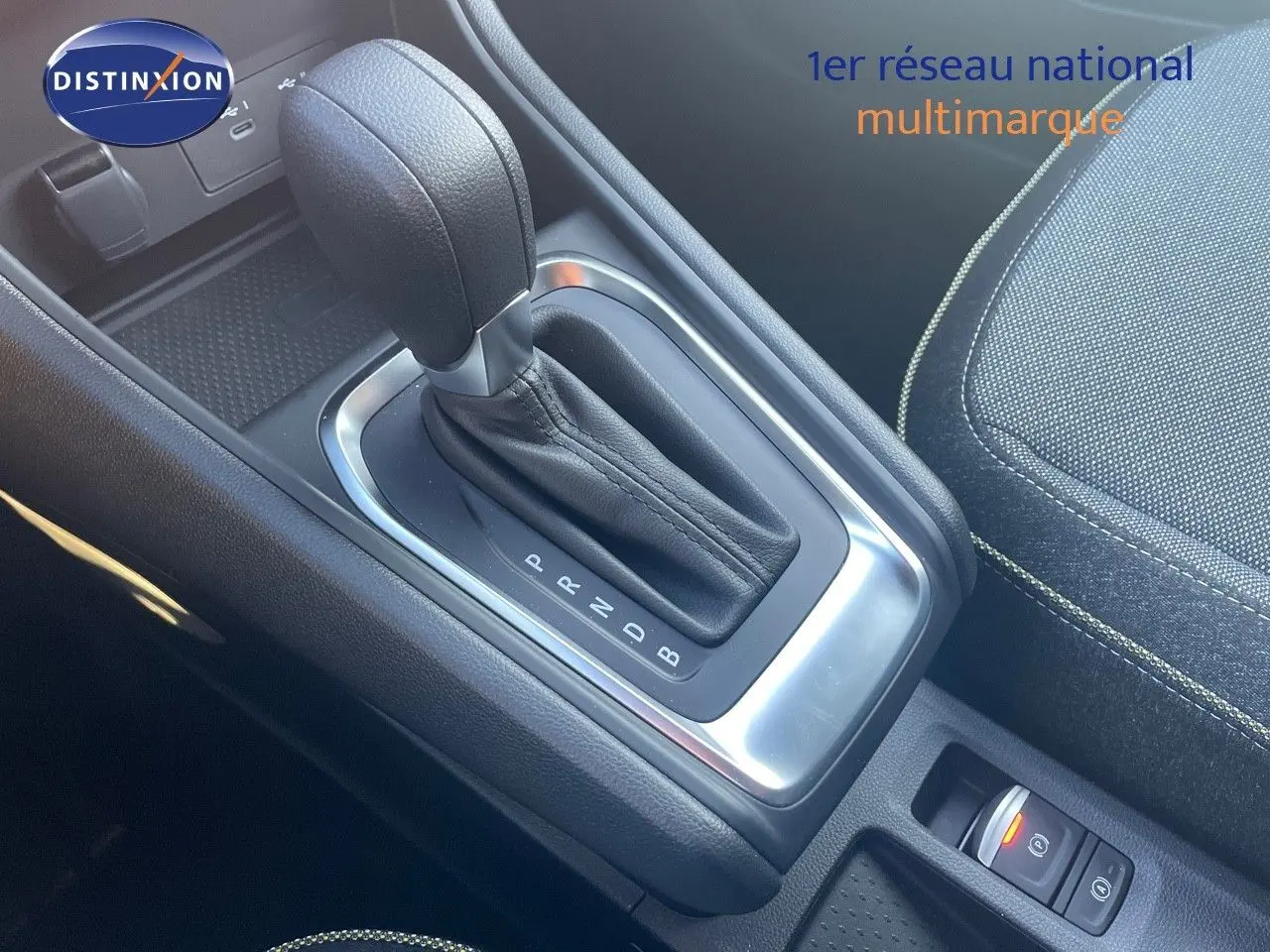 Gros plan sur la console centrale avec levier de vitesse automatique du Renault Captur E-Tech Hybrid 2025, intérieur tissu noir.
