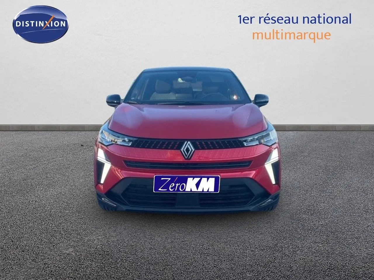 Vue avant d'un Renault Captur E-Tech hybride rouge passion avec toit noir et feux LED allumés.