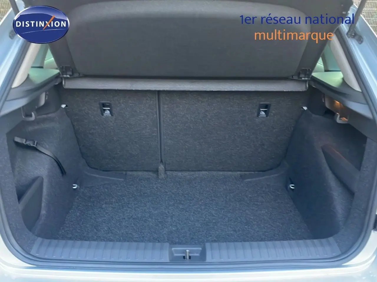 Coffre ouvert vu de l'arrière d'un Skoda Kamiq gris argent métallisé, montrant un espace de chargement propre et spacieux.