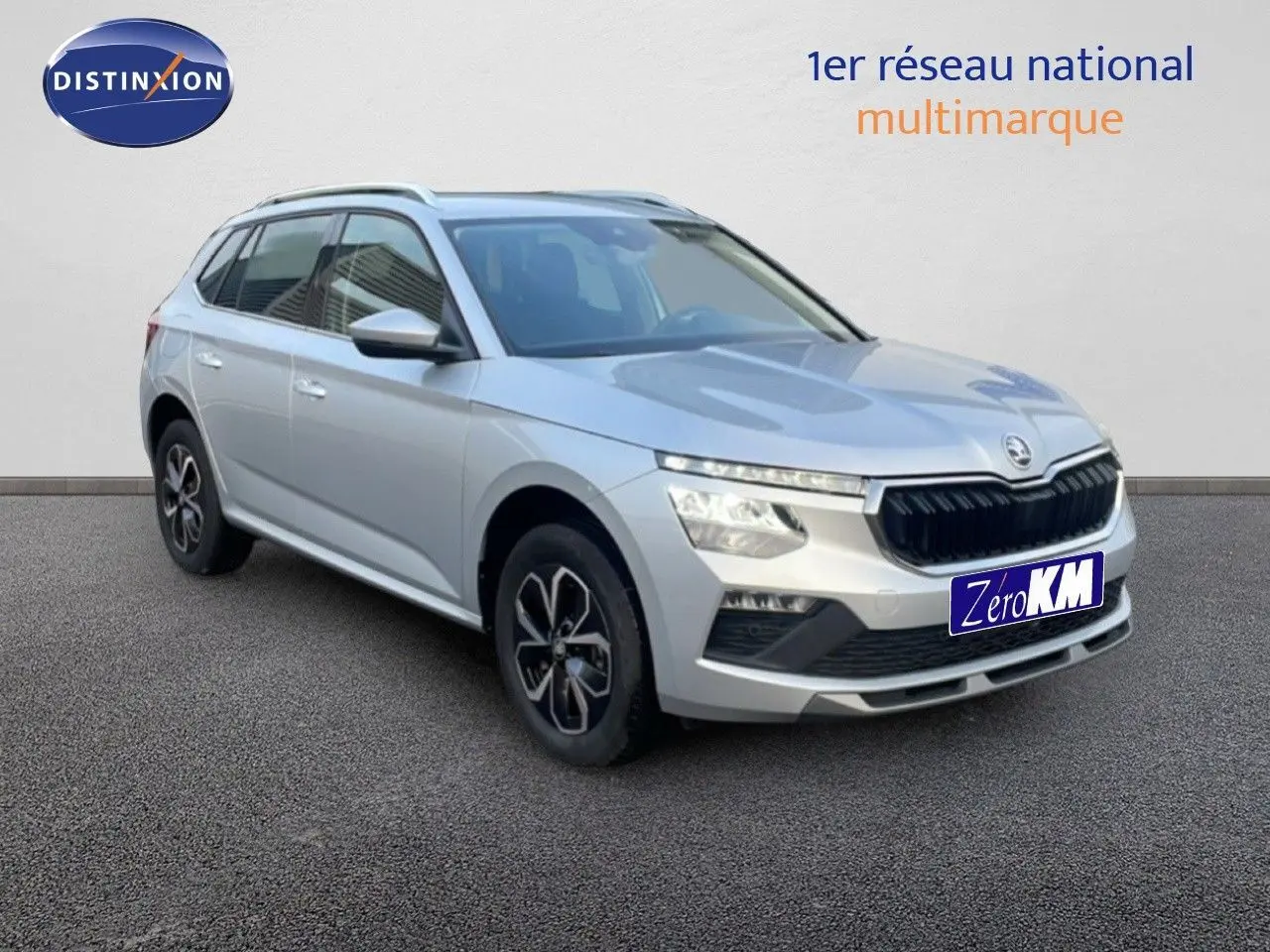 Vue 3/4 avant d'un Skoda Kamiq gris argent métallisé avec jantes bi-ton et calandre noire distinctive.