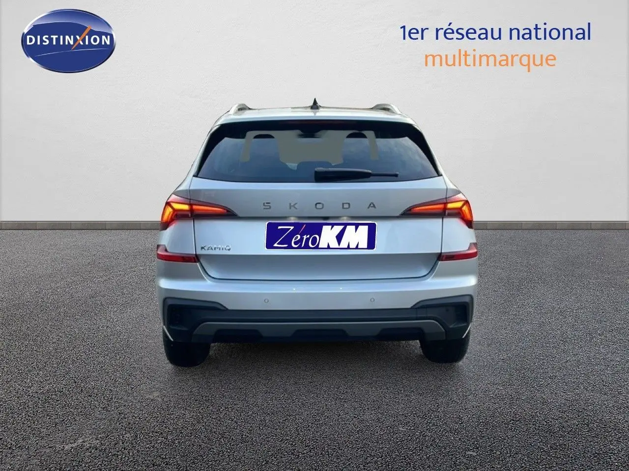 Vue arrière d'un Skoda Kamiq gris argent métallisé avec feux LED allumés sur fond neutre.