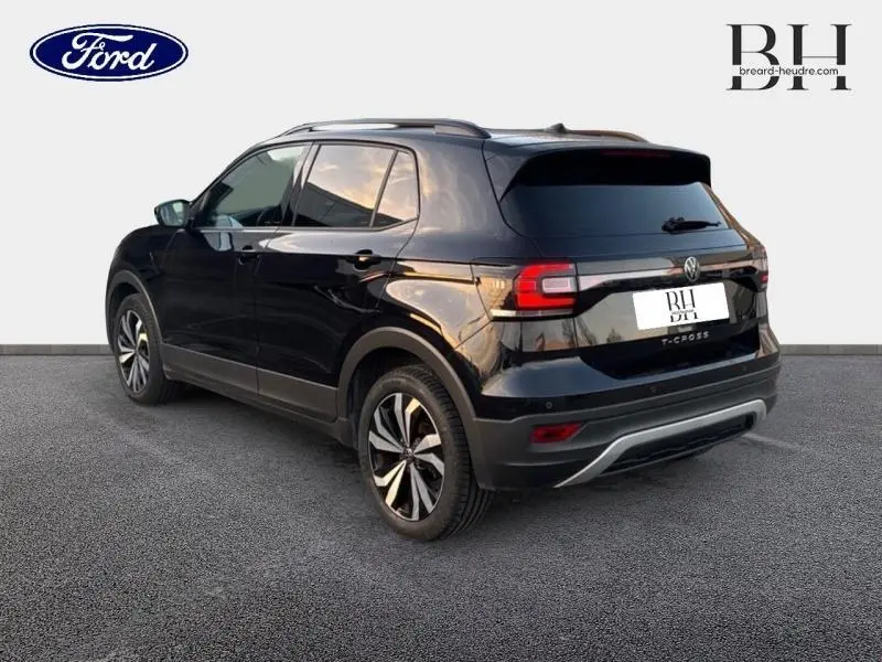 Volkswagen T-Cross noir intense nacré vu en 3/4 arrière droit, avec jantes alliage 17 pouces et barres de toit.