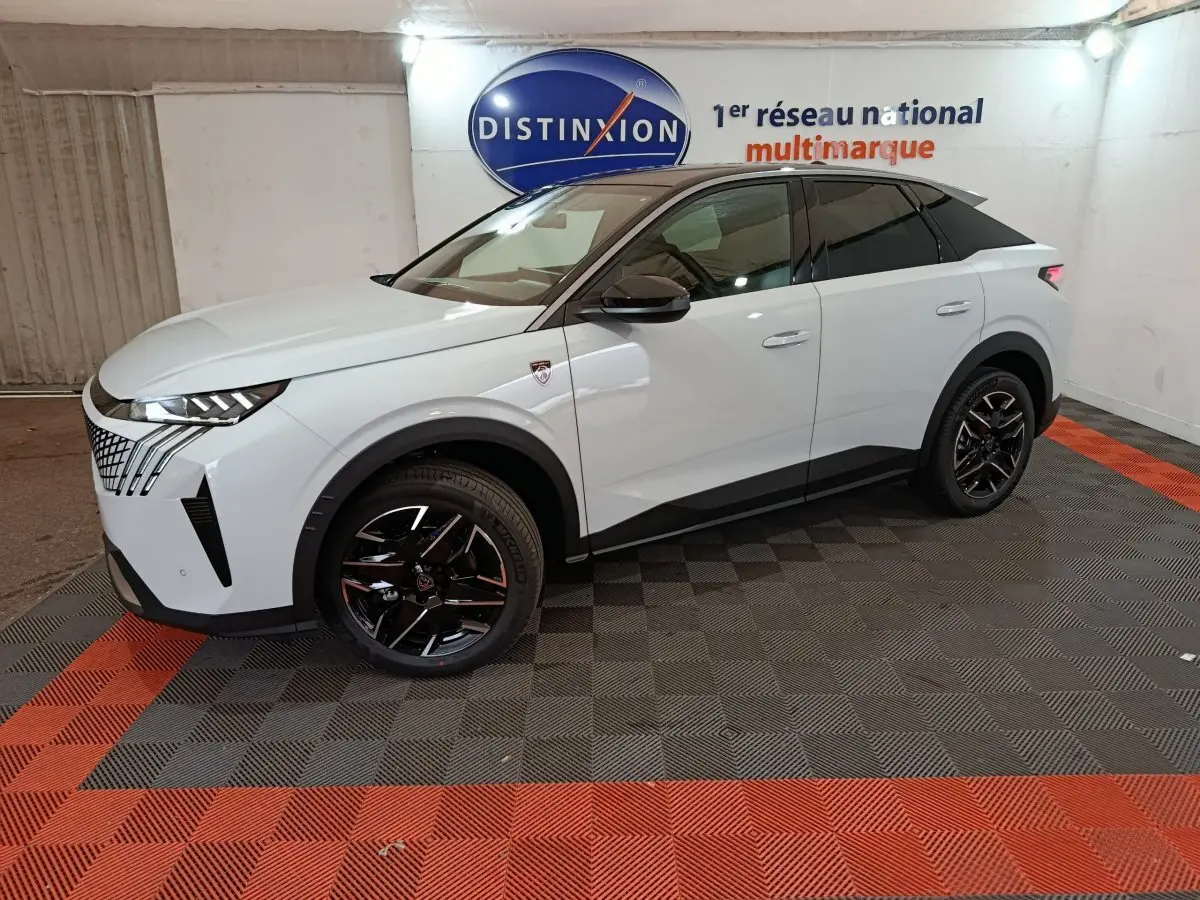 Vue 3/4 avant droit d’un Peugeot 3008 blanc hybride 2025 avec jantes noires et toit noir dans un showroom.