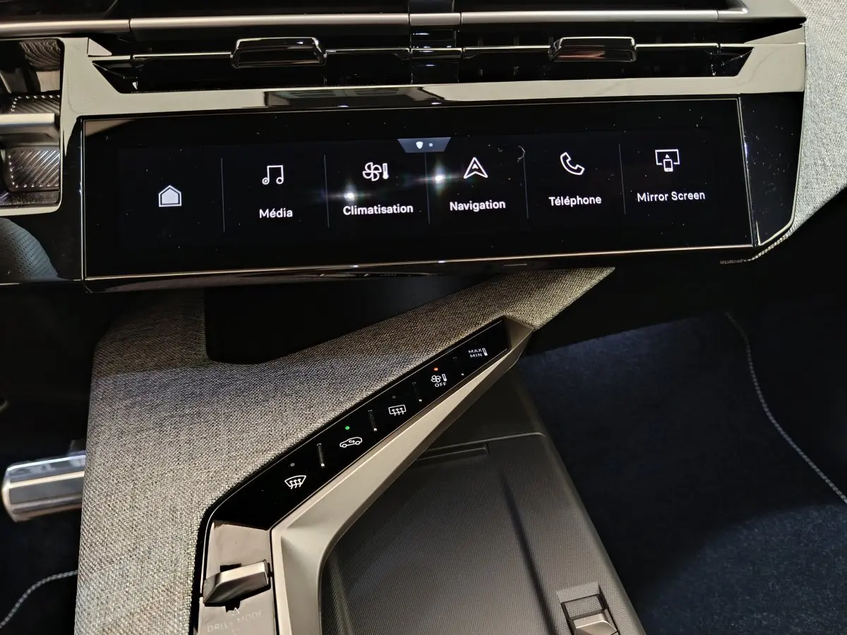 Vue rapprochée de la console centrale du Peugeot 3008 1.2 Hybrid 145 GT 2025, avec écran tactile et commandes climatisation.