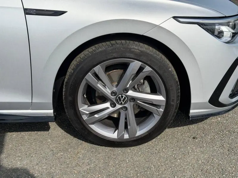 Gros plan sur la roue avant gauche d'une Volkswagen Golf 1.5 eTSI R-Line 2024 en Reflet d'Argent métallisée.
