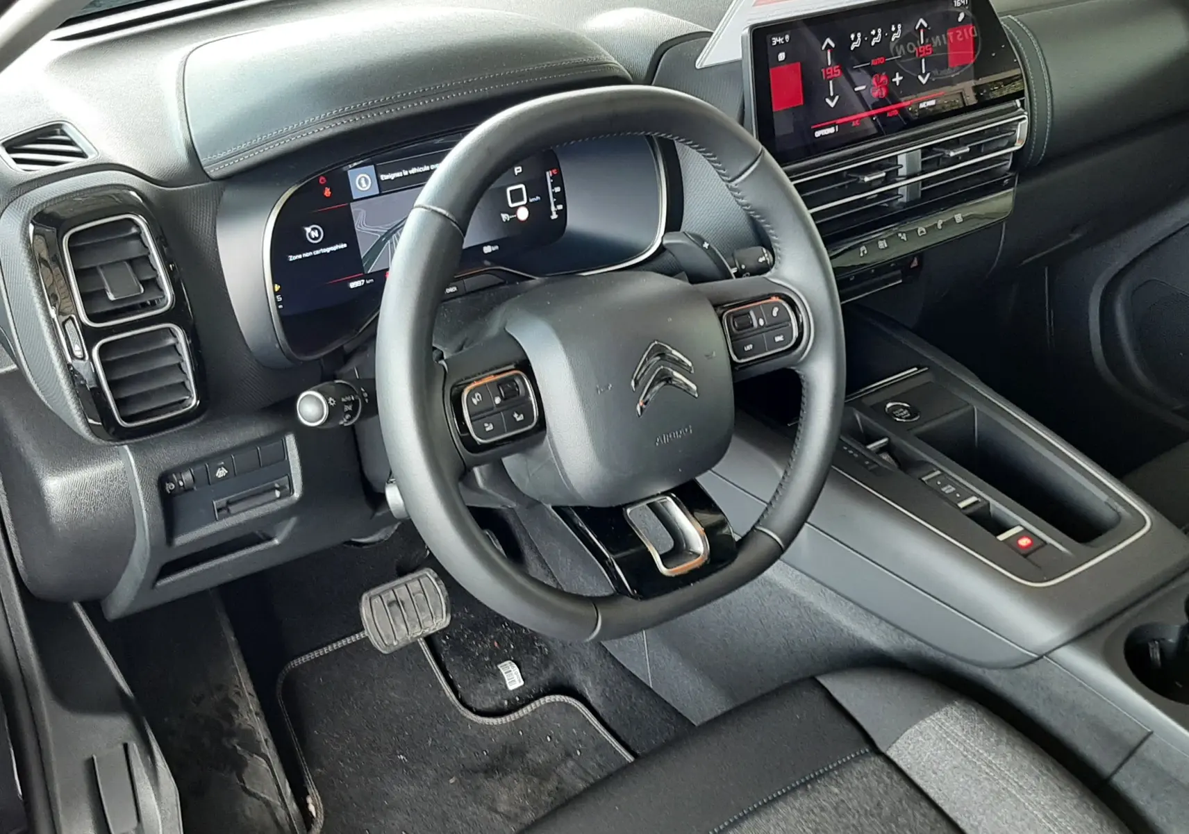 Vue intérieure du poste de conduite du Citroën C5 Aircross 2025, avec tableau de bord numérique et écran tactile central.