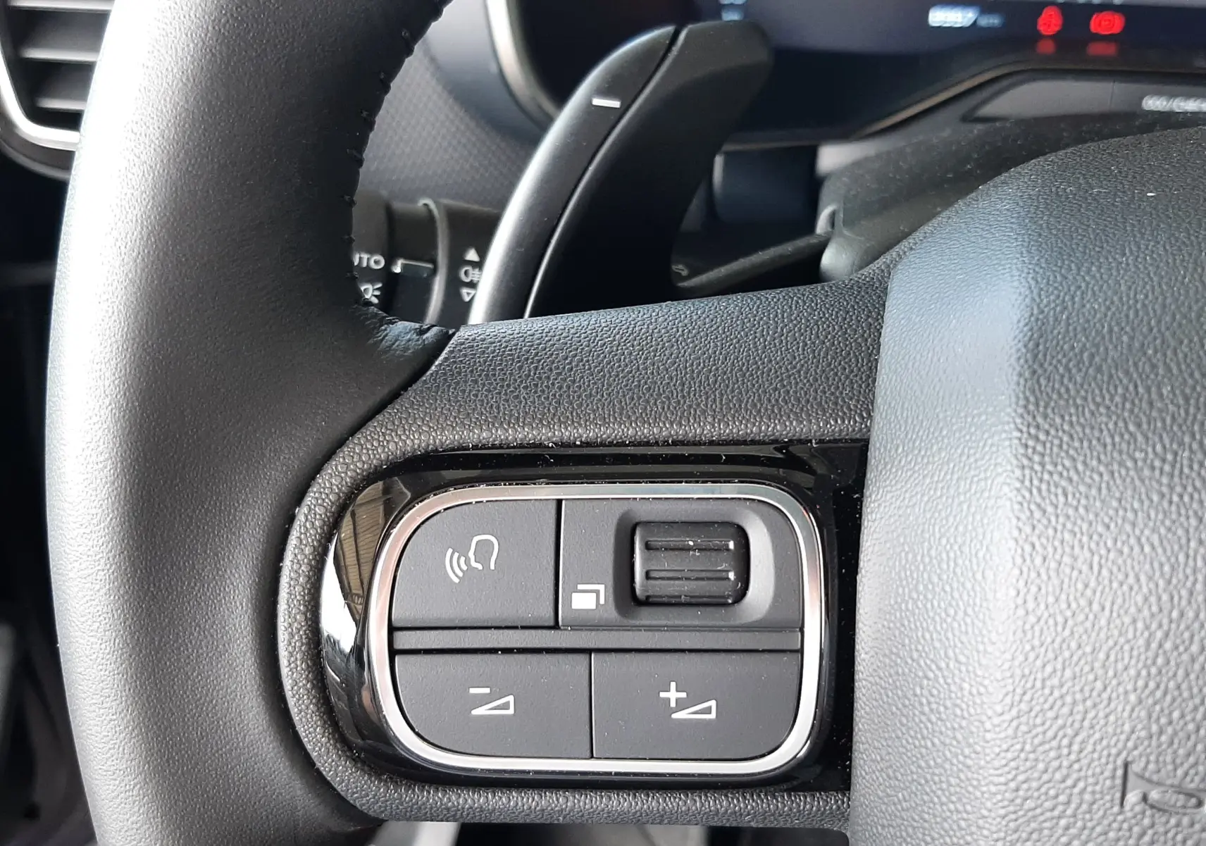 Gros plan sur les commandes au volant côté gauche du Citroën C5 Aircross bleu Eclipse, avec boutons de volume et commande vocale.
