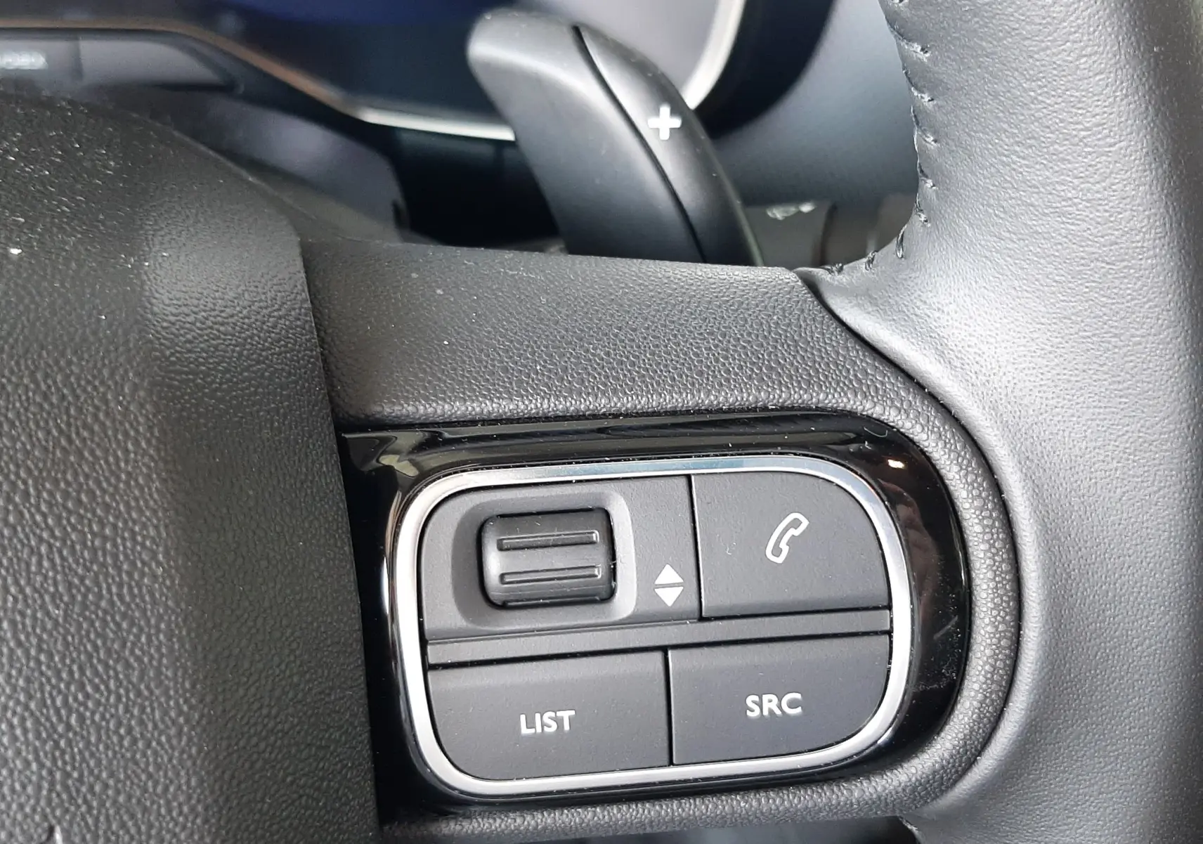 Gros plan sur les commandes multifonctions côté gauche du volant cuir noir du Citroën C5 Aircross 2025.