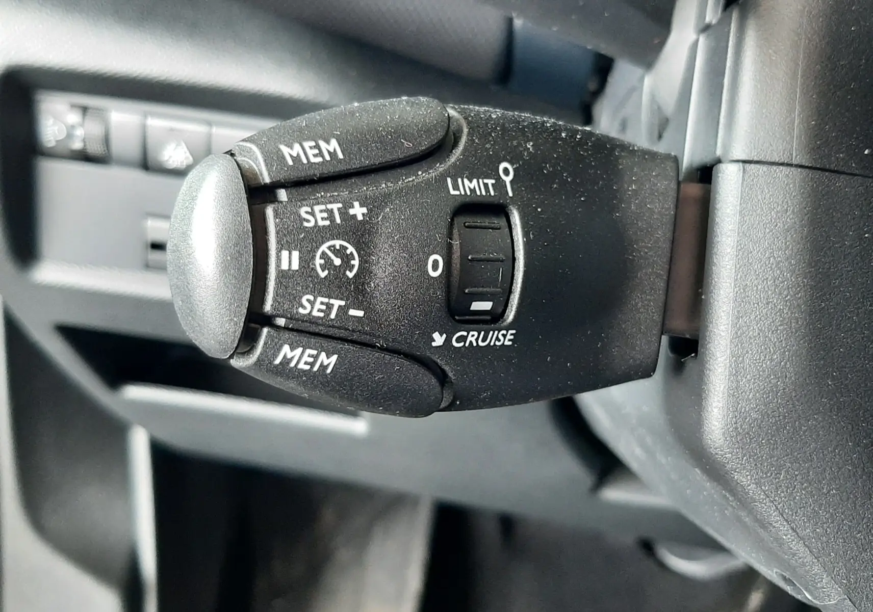 Gros plan sur la commande de régulateur de vitesse noire dans l'habitacle d'une Citroën C5 Aircross 2025.