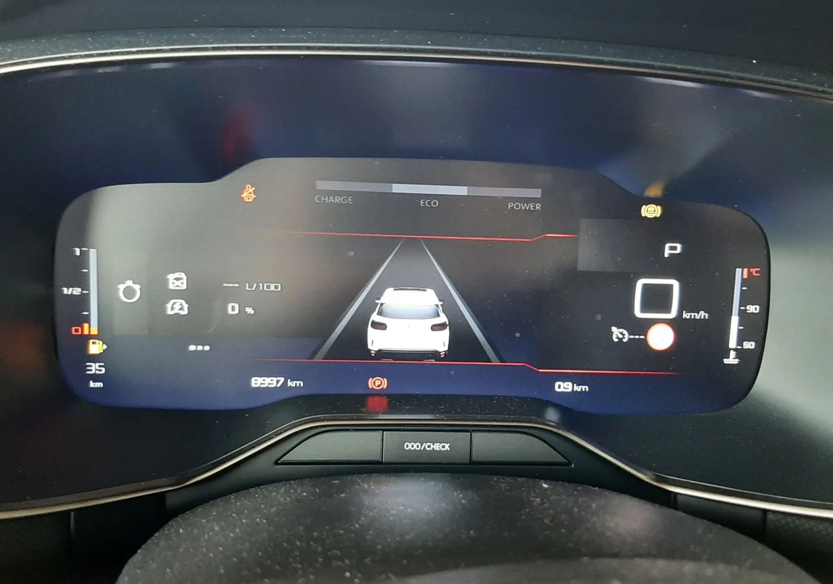 Vue rapprochée du tableau de bord numérique du Citroën C5 Aircross hybride, affichant la vitesse à 0 km/h et l'état de charge.