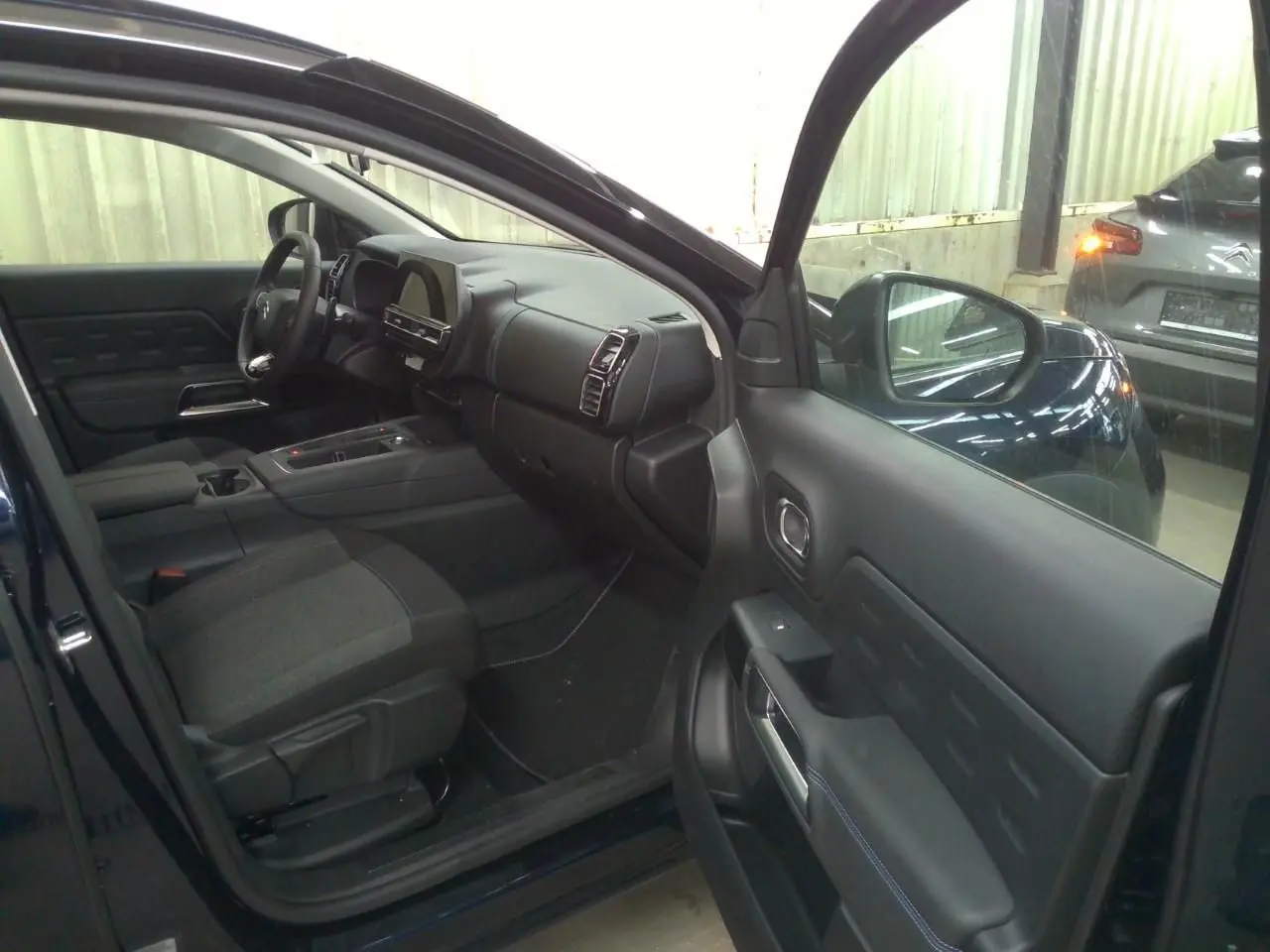 Vue intérieure côté conducteur du Citroën C5 Aircross 2025 bleu Éclipse avec tableau de bord et sièges visibles.