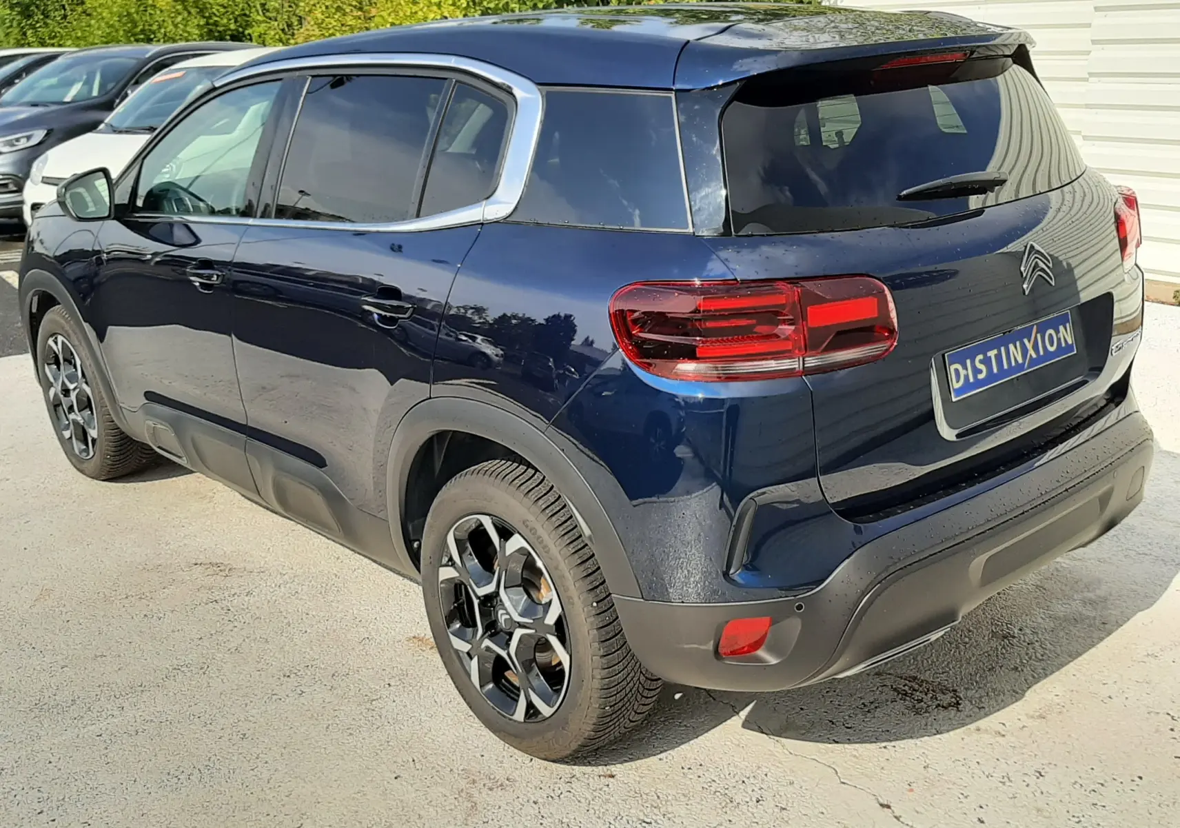 Vue 3/4 arrière droite d'un Citroën C5 Aircross bleu éclipse avec jantes bi-ton et vitres teintées.