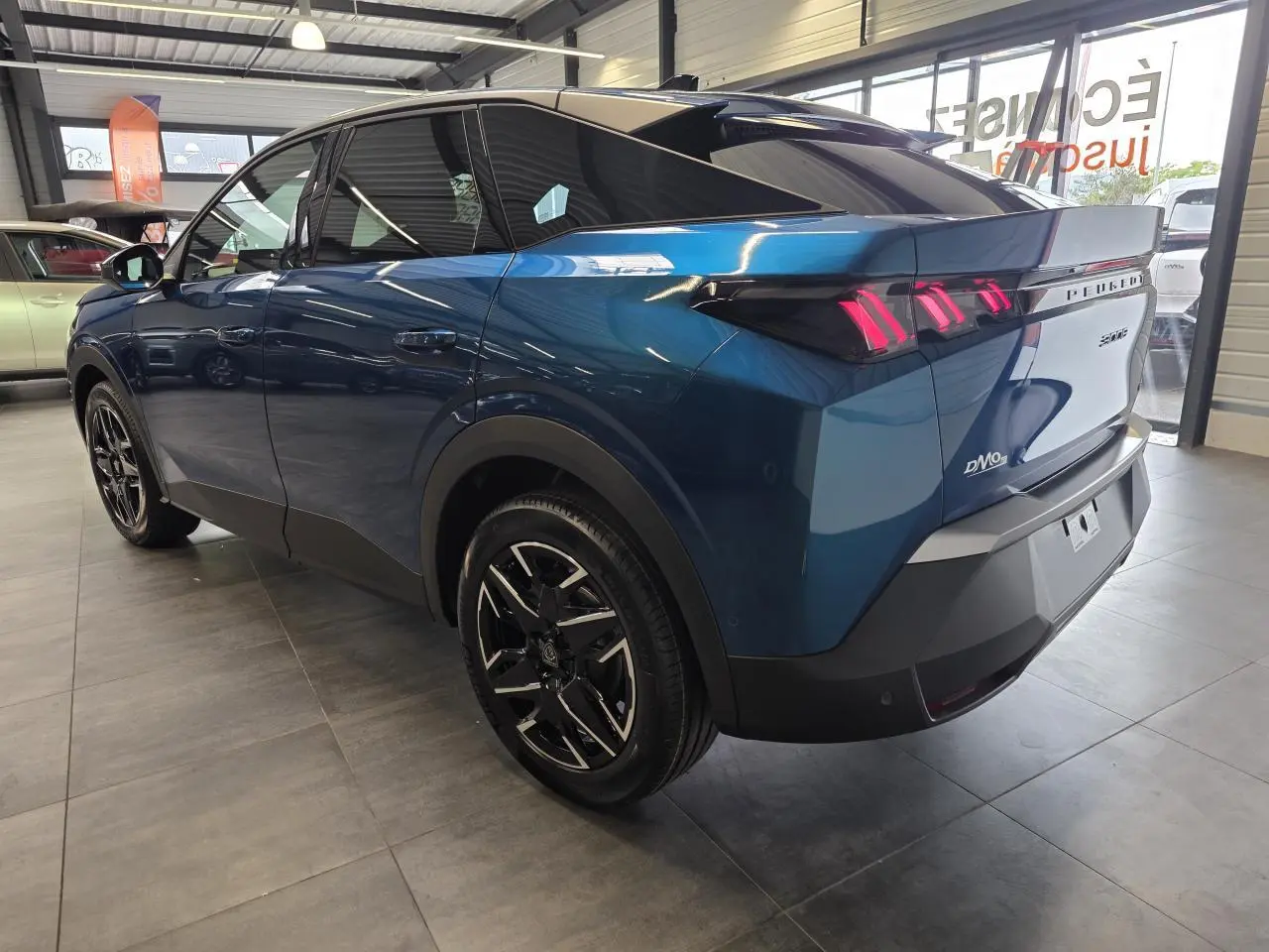 Peugeot 3008 bleu métallisé vue 3/4 arrière droit, feux arrière LED à 3 griffes et jantes alliage 18 pouces.