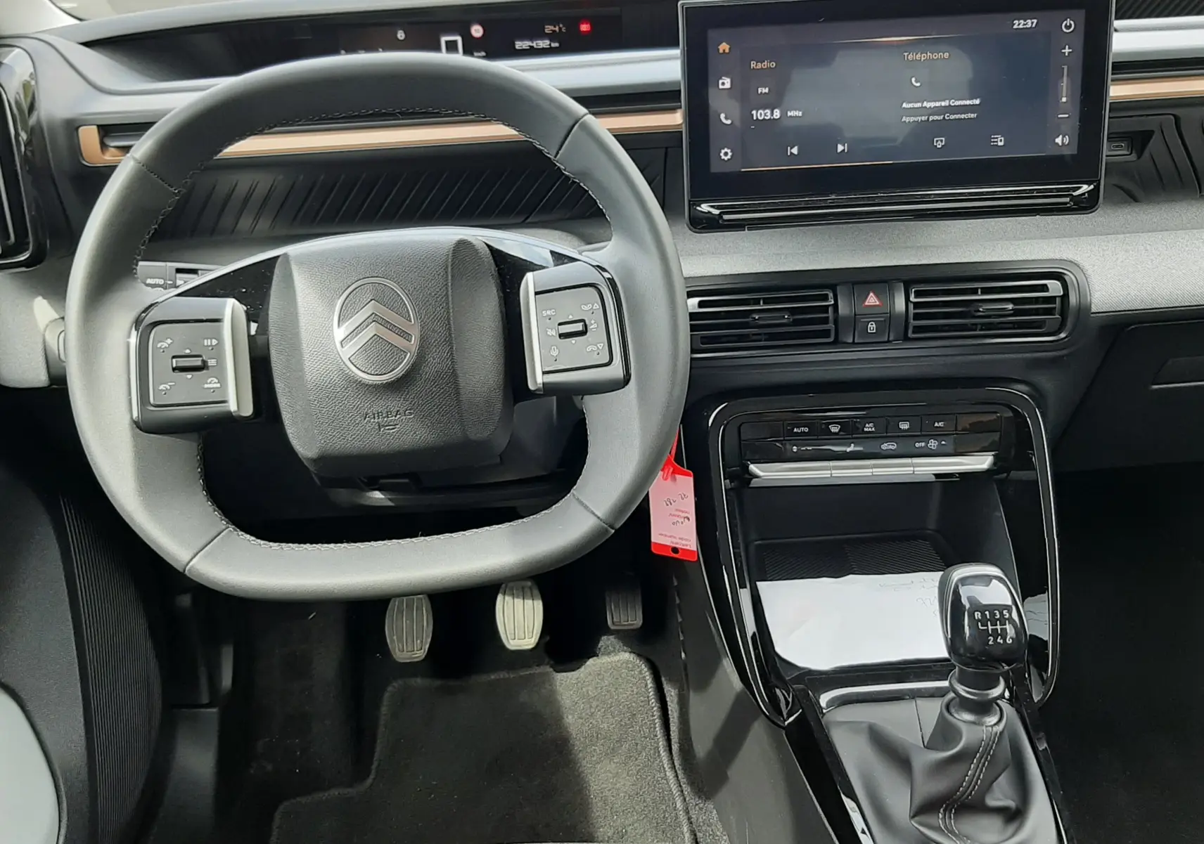 Vue intérieure du poste de conduite de la Citroën C3 Aircross 2025, volant compact et levier de vitesse manuel visibles.