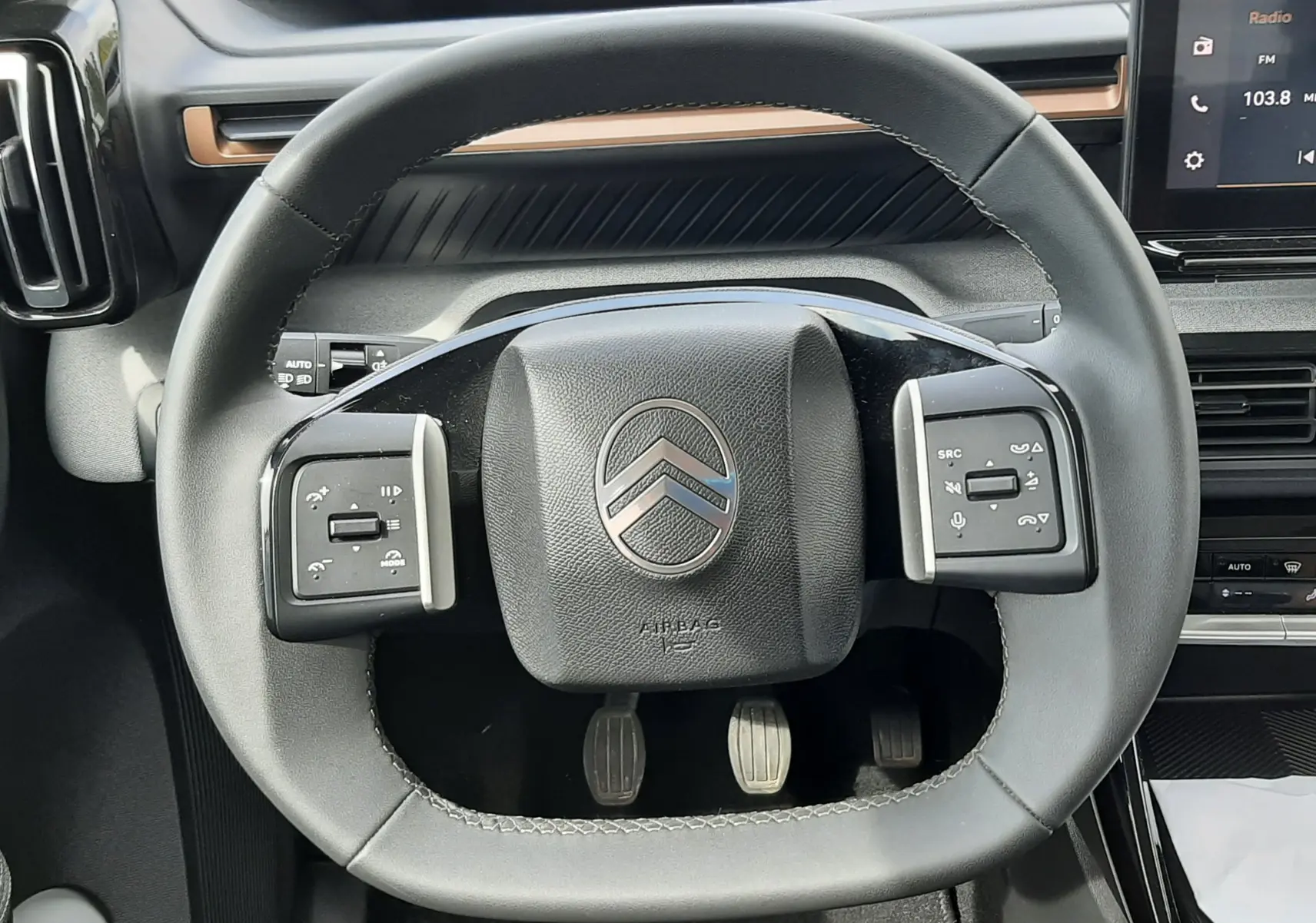 Vue rapprochée du volant carré noir du Citroën C3 Aircross 2025 avec commandes intégrées et tableau de bord numérique.