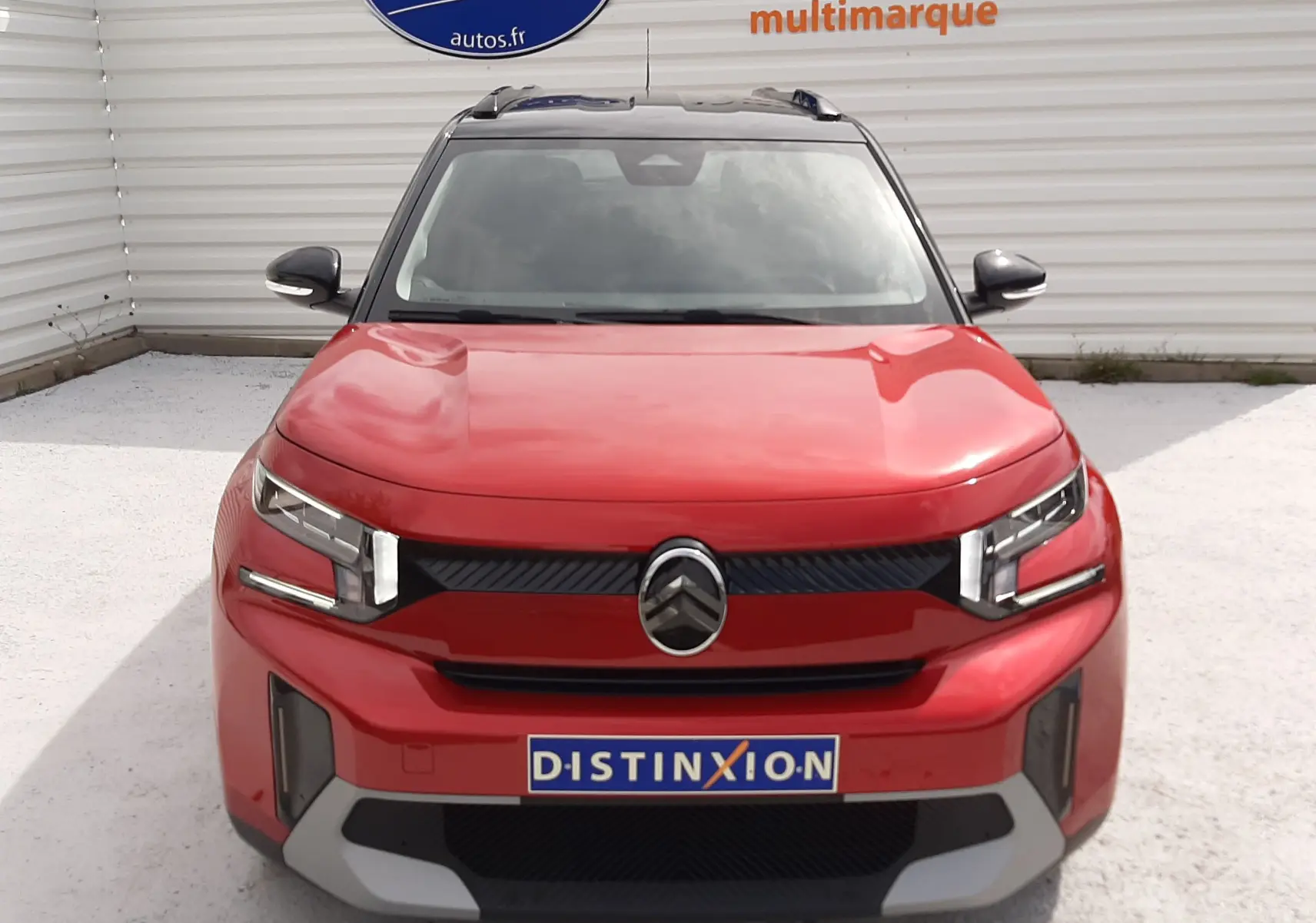 Vue frontale d'un Citroën C3 Aircross rouge Elixir avec toit noir, calandre noire et logo Citroën centré.