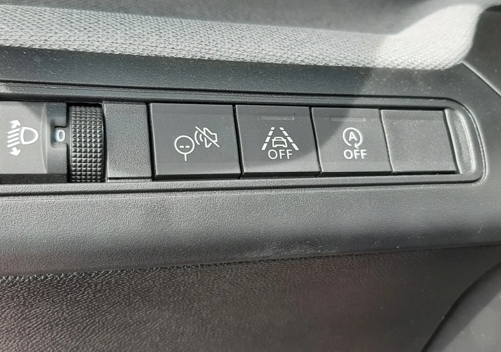 Gros plan sur les boutons de commande intérieurs du tableau de bord de la Citroën C3 Aircross 2025, finition rouge Elixir.