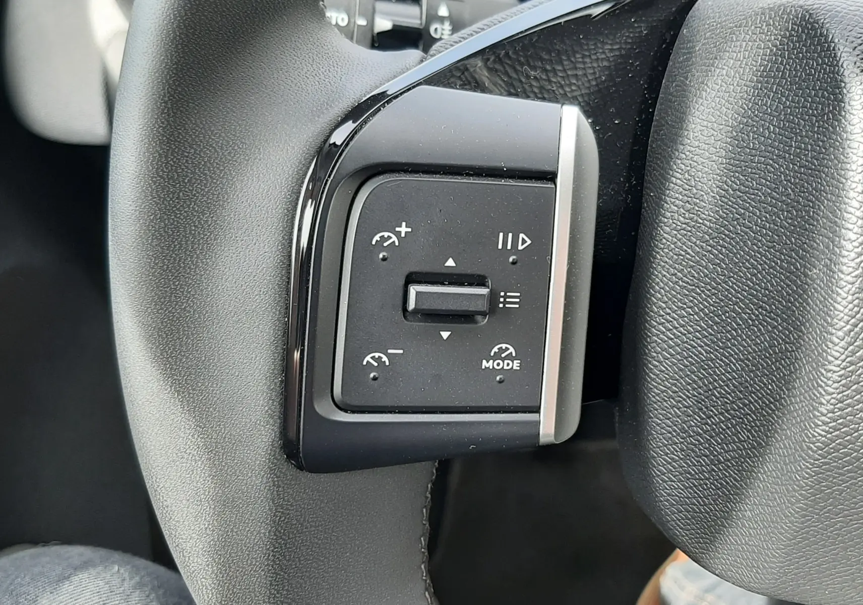 Gros plan sur les commandes de régulateur de vitesse au volant noir du Citroën C3 Aircross 2025.