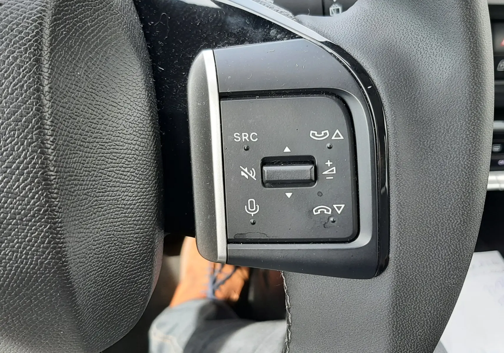 Gros plan sur les commandes au volant côté gauche du Citroën C3 Aircross rouge Elixir, avec boutons de volume et appel.