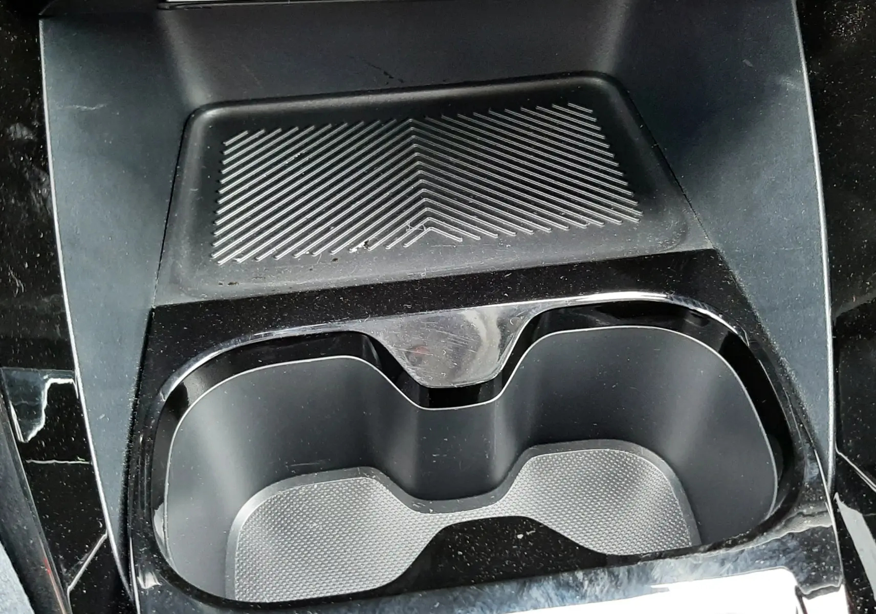 Gros plan sur le porte-gobelets noir et la zone de rangement texturée au centre de la console d'une Citroën C3 Aircross 2025.