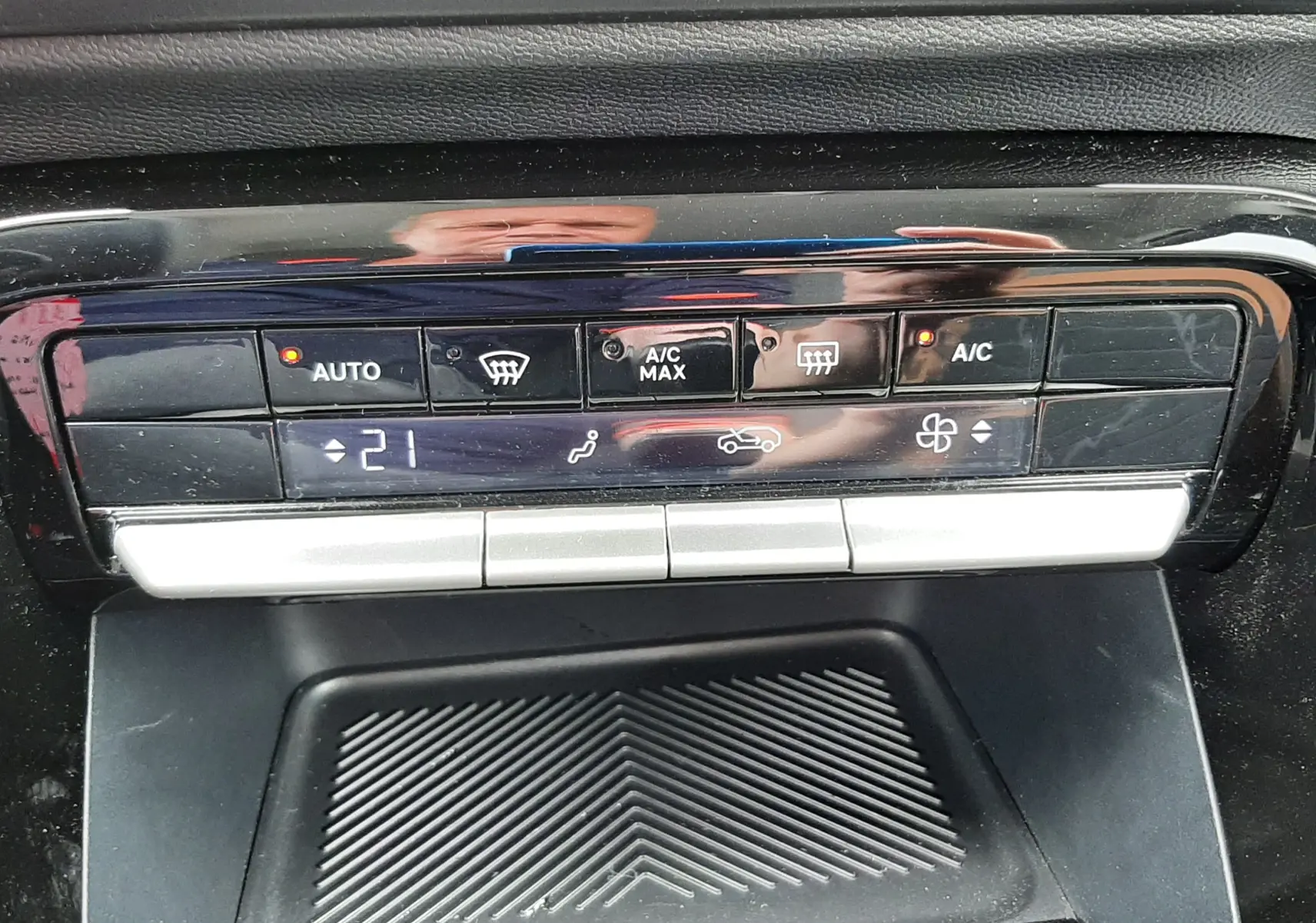 Gros plan sur la console centrale du Citroën C3 Aircross rouge Elixir, affichant la climatisation automatique à 21°C.