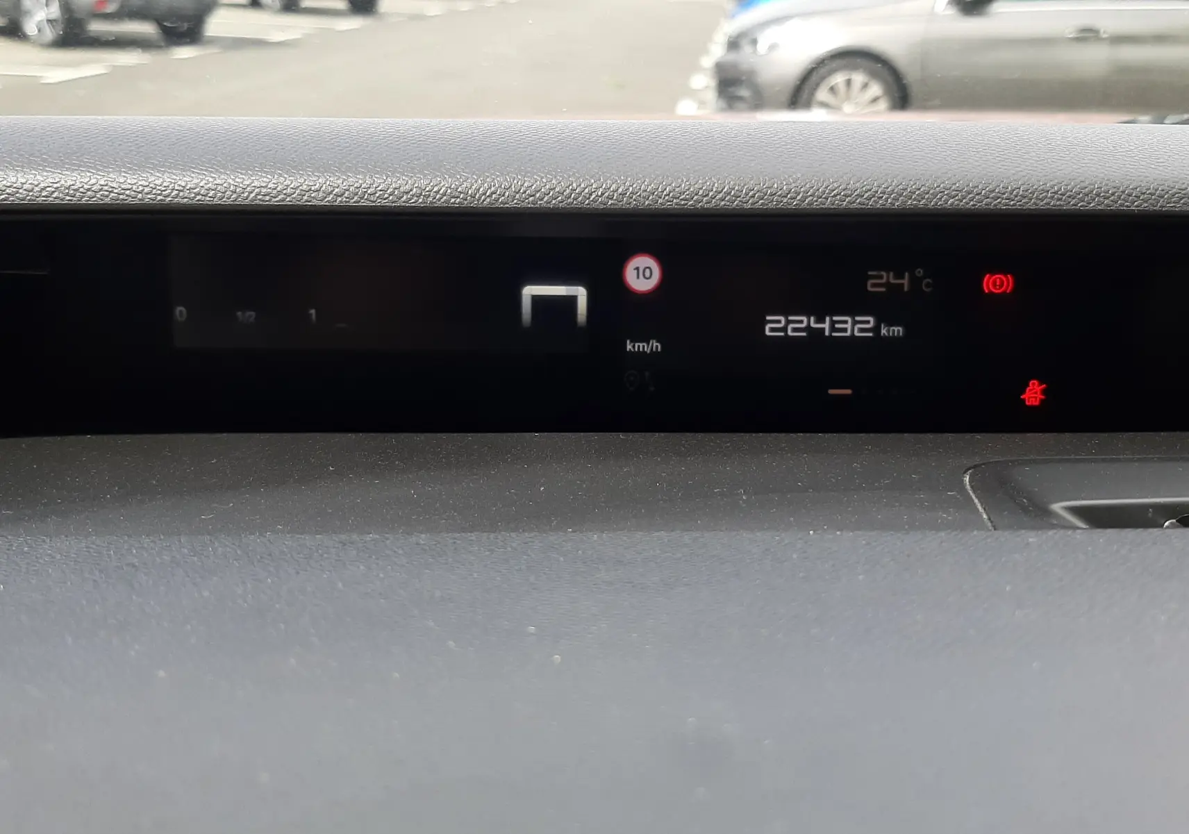 Vue intérieure du tableau de bord numérique de la Citroën C3 Aircross rouge Elixir, affichant la vitesse et la température.