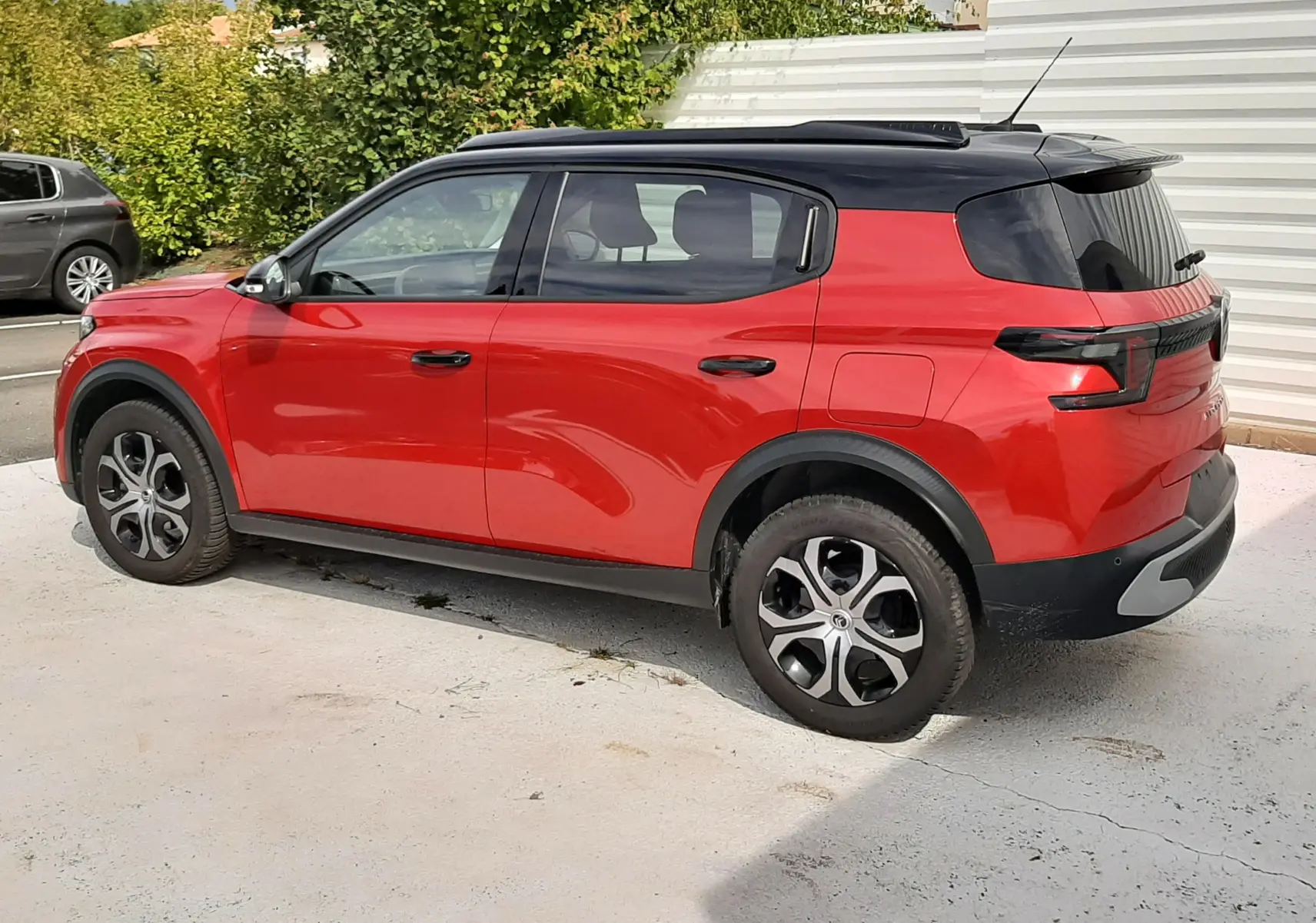 Vue latérale droite d'un Citroën C3 Aircross rouge Elixir avec toit noir, roues distinctives et vitres teintées.
