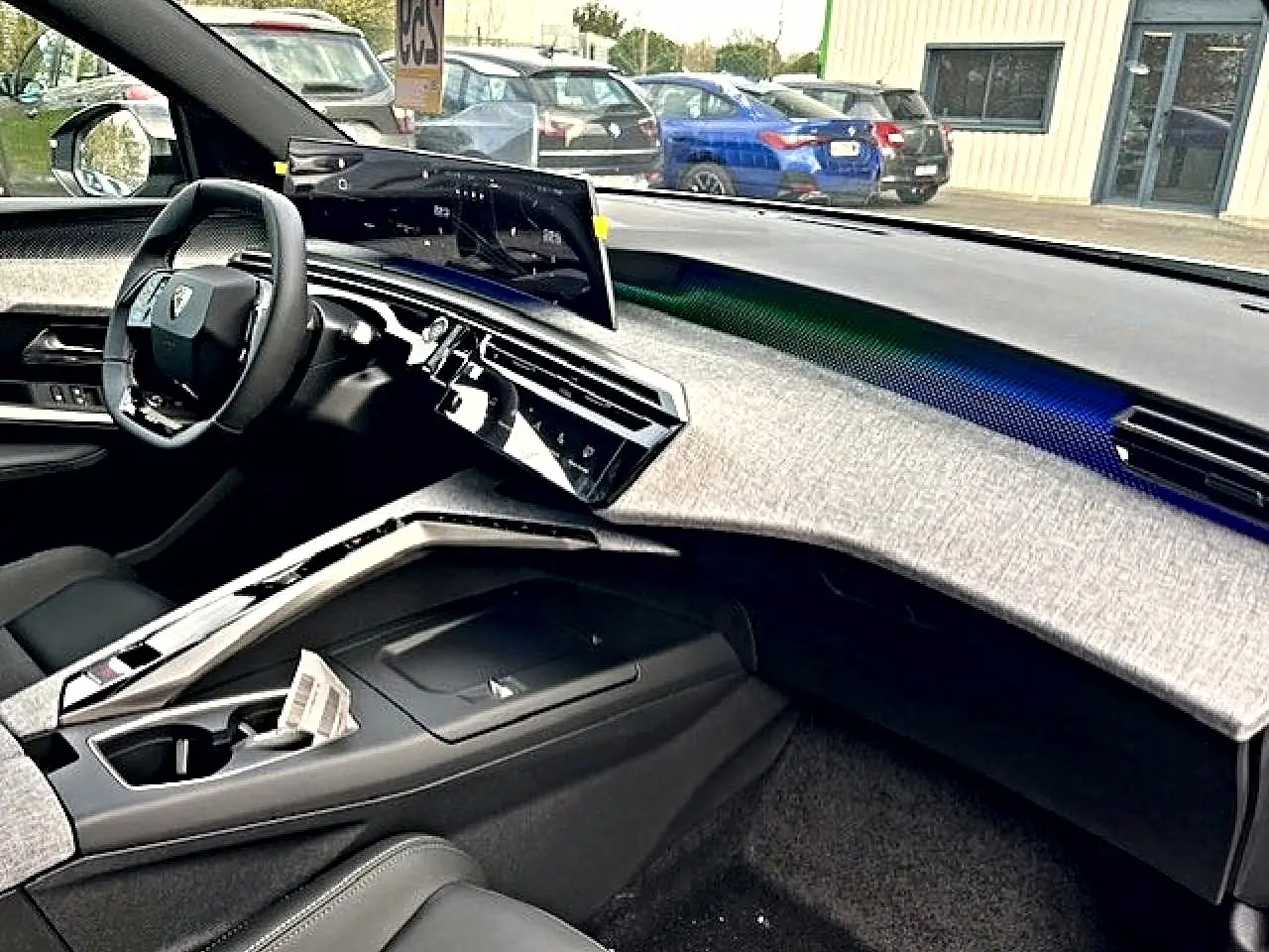 Vue intérieure côté conducteur du Peugeot 3008 gris titane 2025, avec tableau de bord moderne et écran tactile incurvé.