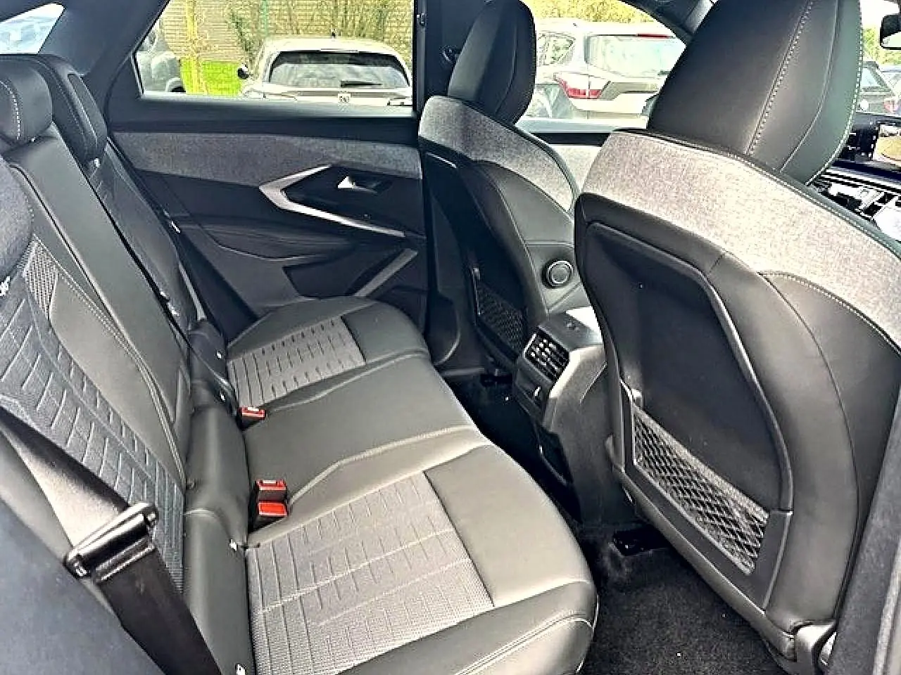 Vue intérieure arrière côté droit du Peugeot 3008 gris titane, montrant les sièges et les rangements au dos des sièges avant.