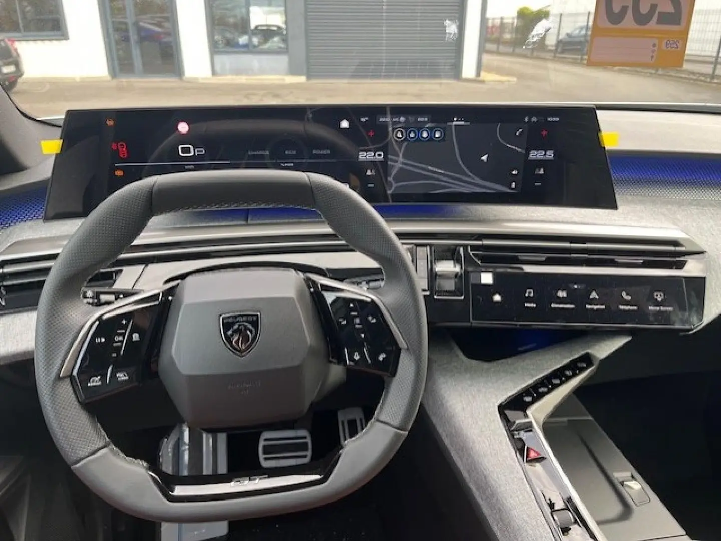 Vue intérieure du poste de conduite du Peugeot 3008 gris titane, avec volant multifonction et écran tactile panoramique.
