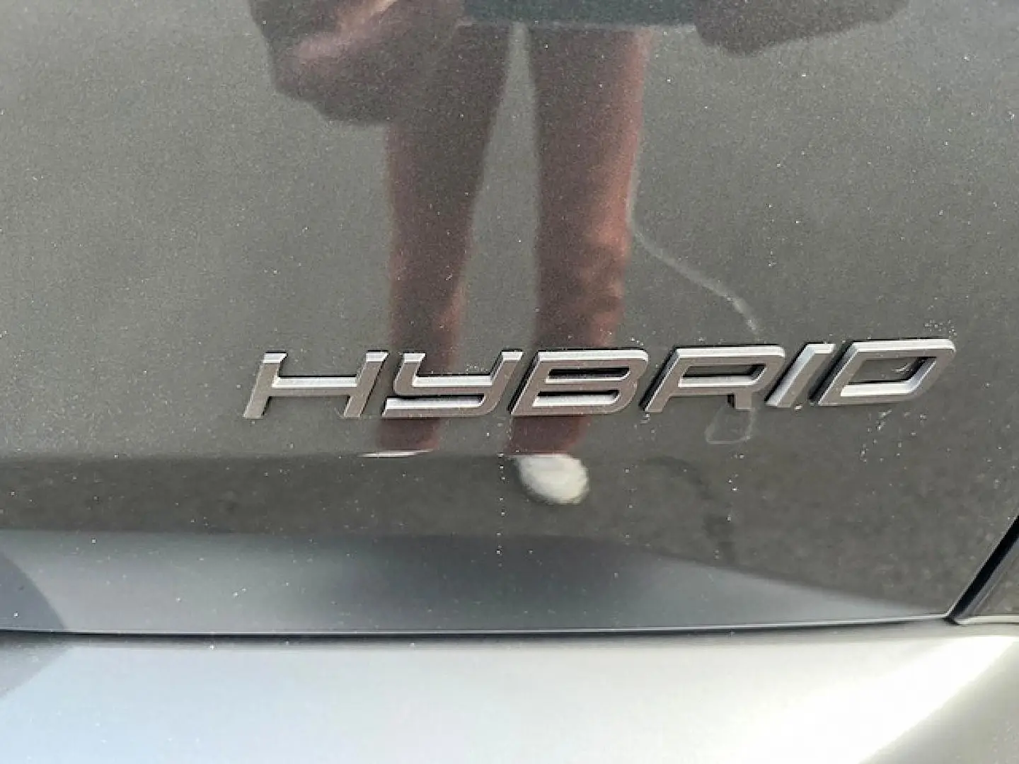 Gros plan sur l’inscription « Hybrid » sur la carrosserie gris titane d’un Peugeot 3008 2025.