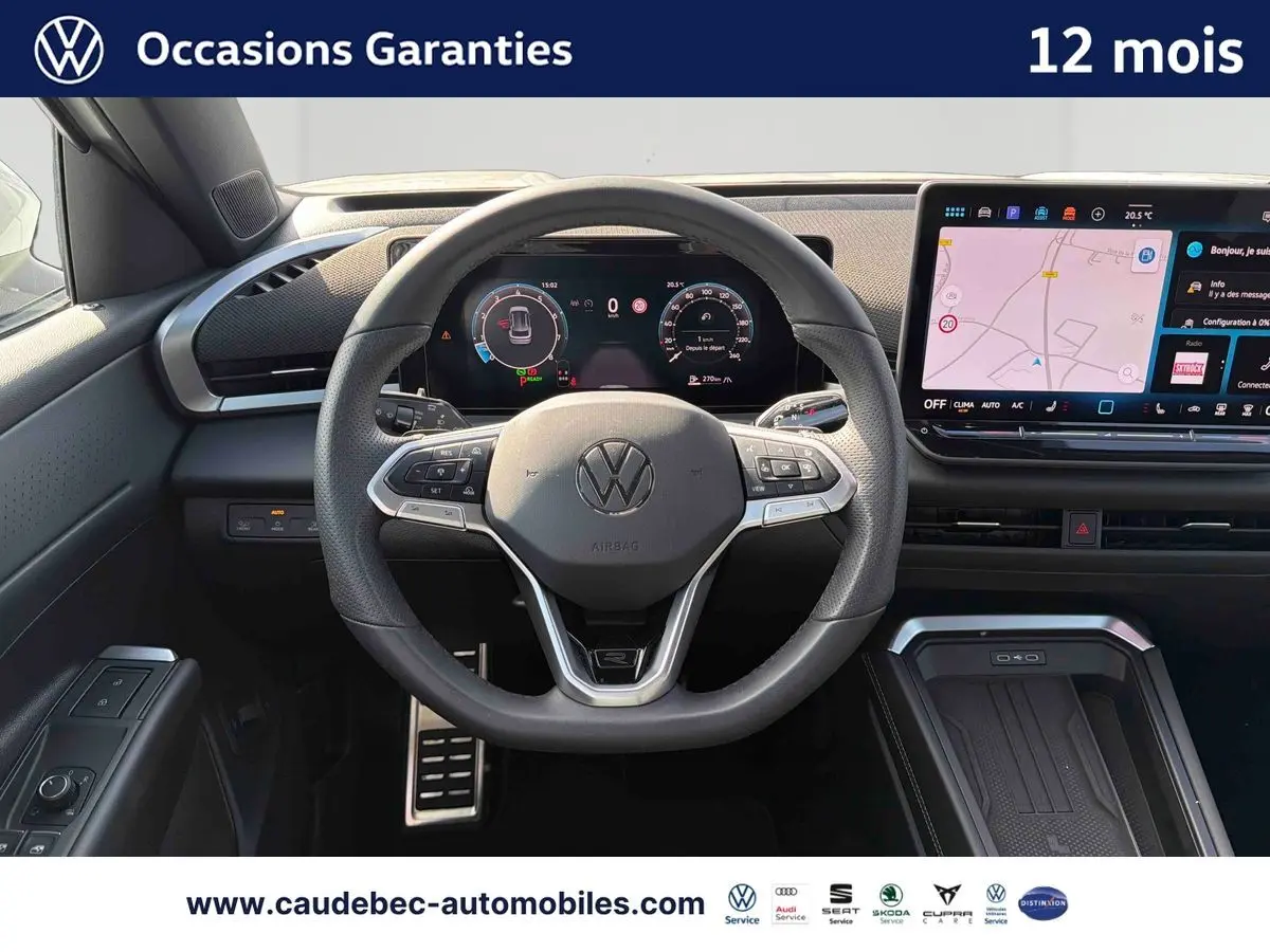 Vue intérieure centrée sur le volant sport cuir du Volkswagen T-Roc blanc avec tableau de bord numérique et écran tactile.