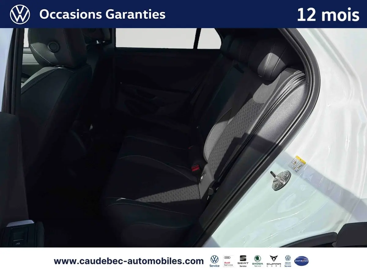 Vue intérieure côté droit des sièges arrière noirs du Volkswagen T-Roc blanc avec porte ouverte.