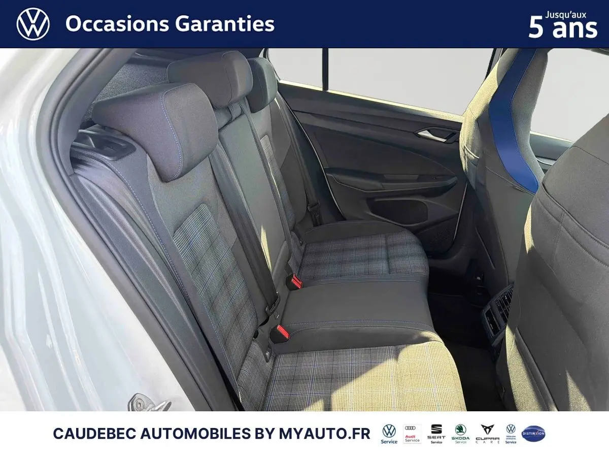 Vue intérieure côté gauche des sièges arrière de la Volkswagen Golf 1.5 eHybrid 2026 blanche avec sellerie tissu à motif tartan.