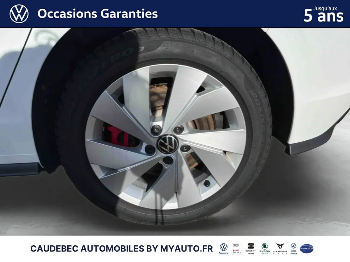 Gros plan sur la jante alliage 17'' Richmond argentée avec logo VW centrale sur Volkswagen Golf blanche.