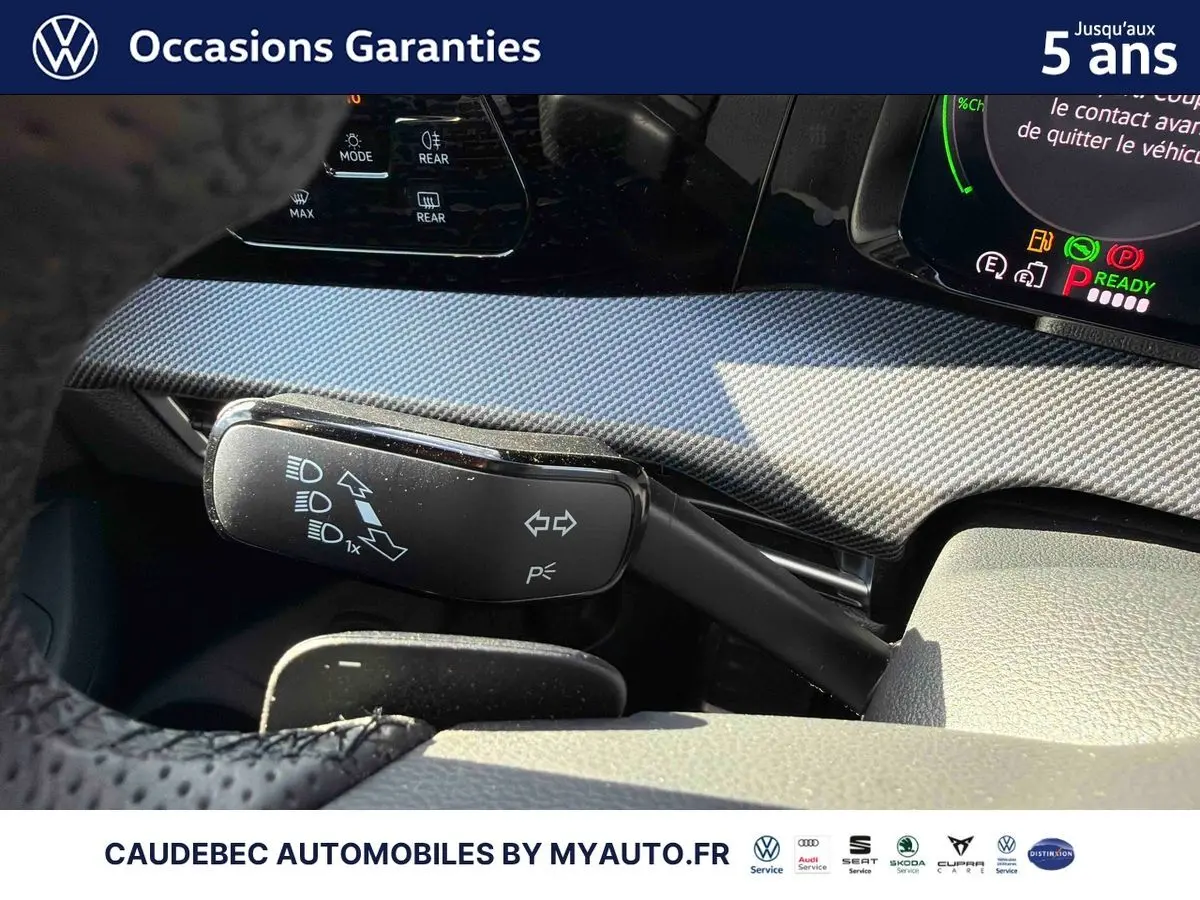 Gros plan sur la commande des clignotants et tableau de bord avec finition carbone de la Volkswagen Golf 1.5 eHybrid blanche.