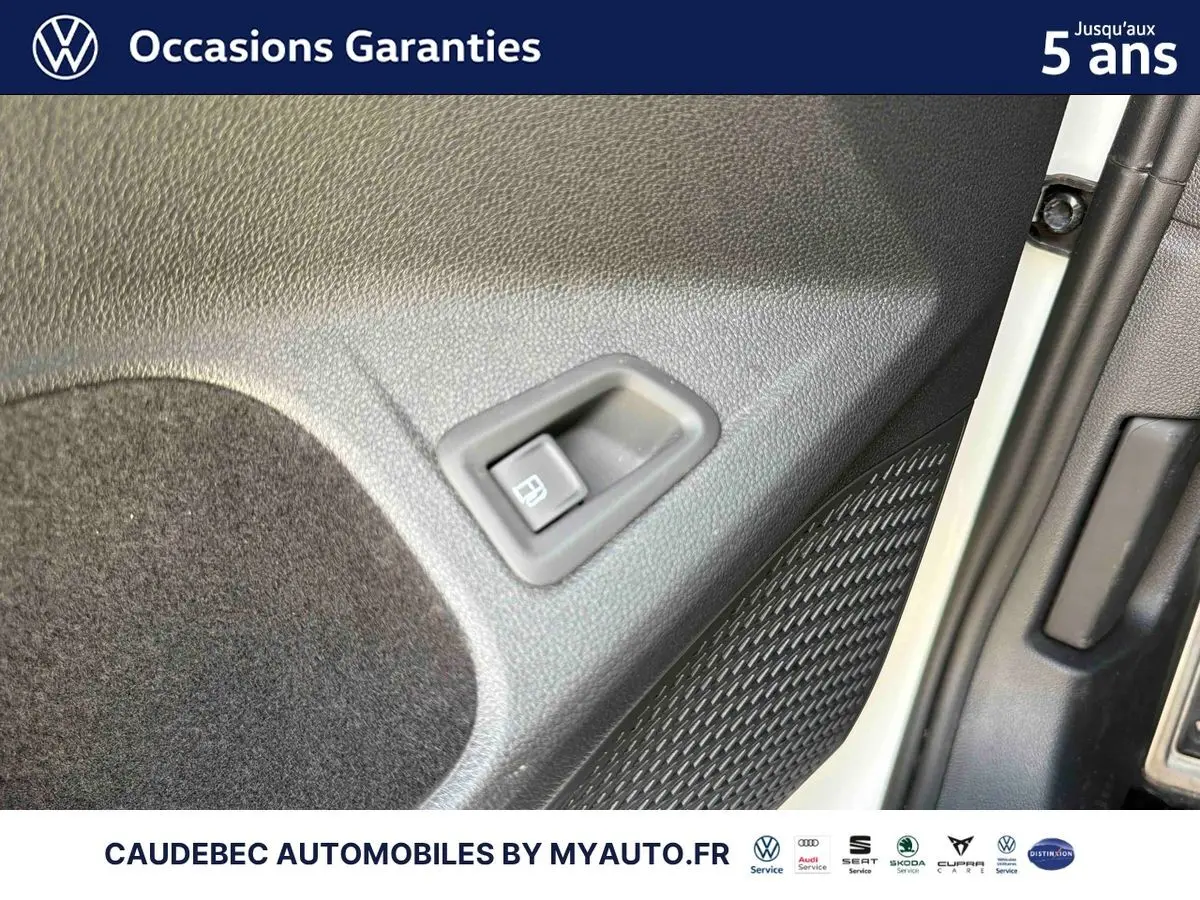 Détail du bouton de déverrouillage électrique sur la portière côté droit d'une Volkswagen Golf 1.5 eHybrid blanche.