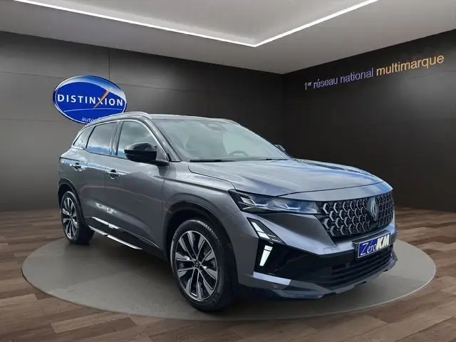 Renault Austral PH2 Techno hybride gris schiste avec toit noir, vue 3/4 avant dans showroom lumineux.