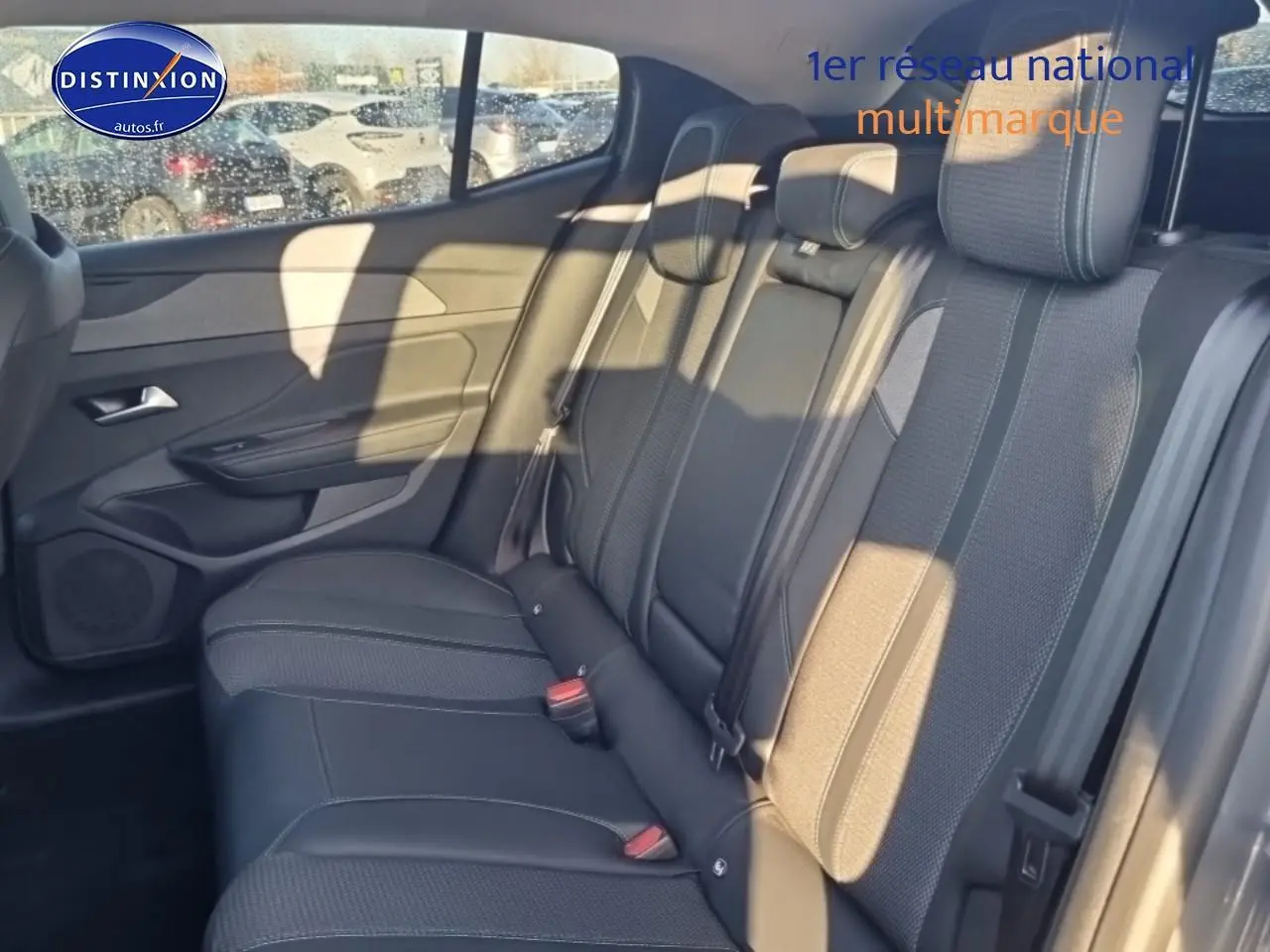 Vue latérale droite de la banquette arrière en tissu gris de la Peugeot 408 Hybrid 145 allure 2025 avec ceintures et appuie-têtes.