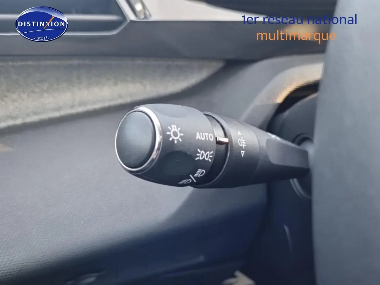 Gros plan sur la commande des phares à gauche du volant dans l’habitacle du Peugeot 408 gris sellenium e.