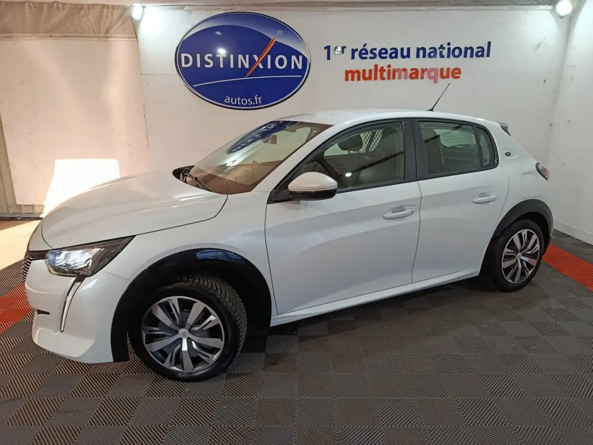 Peugeot 208 Electrique Active Business blanc vue de profil côté gauche en intérieur avec jantes stylisées.