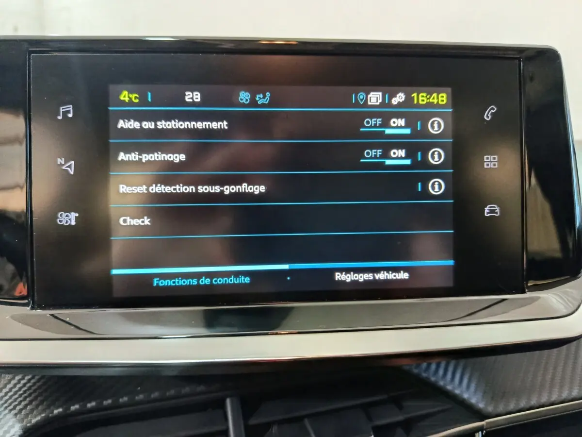 Écran tactile central de la Peugeot 208 électrique Active Business 2020 affichant les réglages d’aide à la conduite.