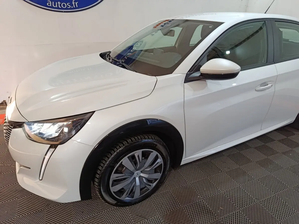 Peugeot 208 électrique blanche vue 3/4 avant droit, avec phares LED et jantes spécifiques au modèle.