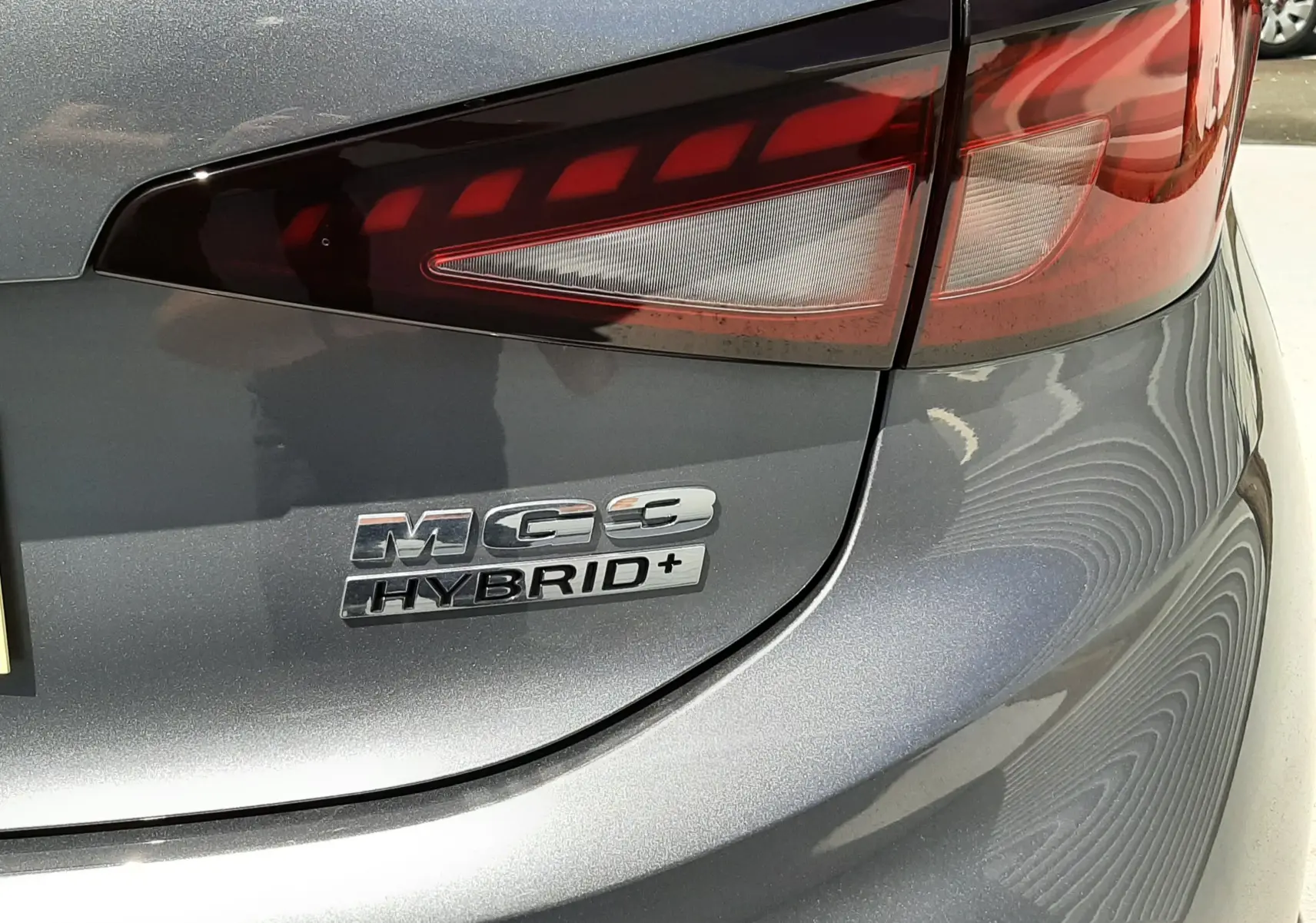 Gros plan sur le feu arrière droit et le badge Hybrid+ d’une MG3 gris métallisé Hampstead.