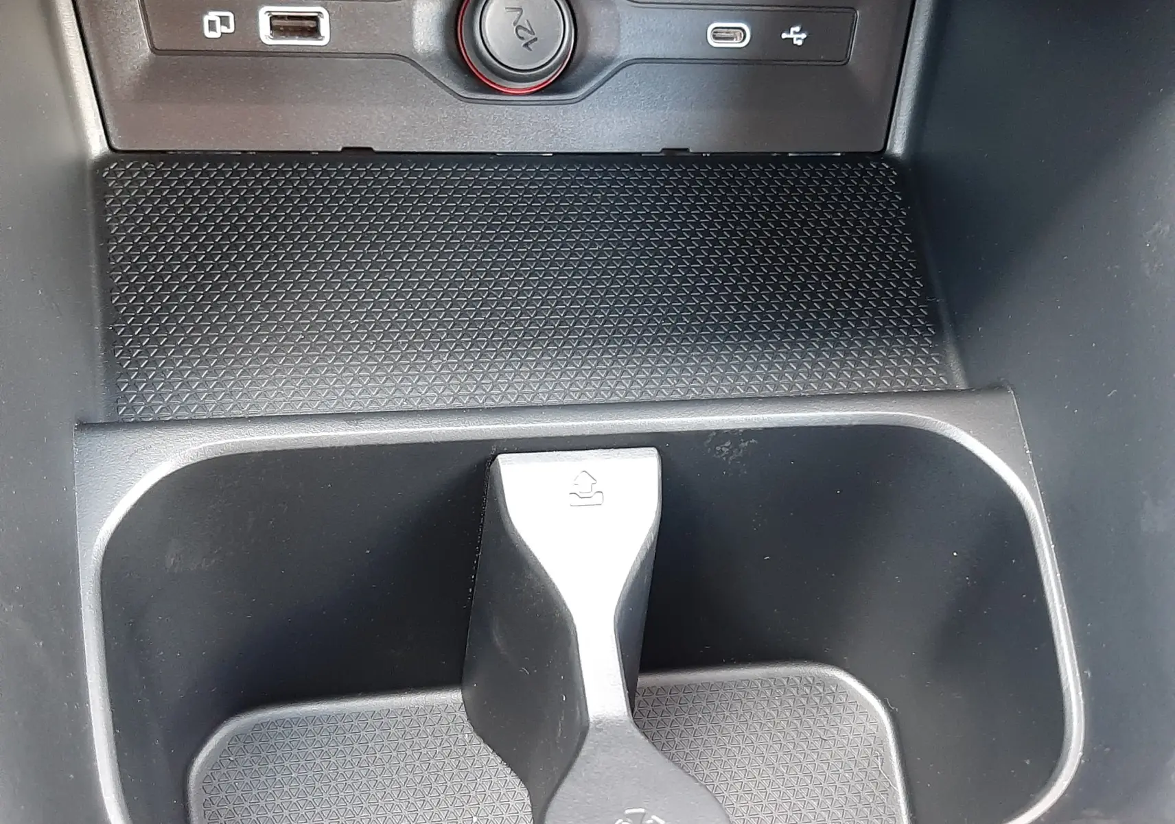 Gros plan intérieur sur la console centrale noire du MG3 2026, montrant porte-gobelets et prises USB et 12V.